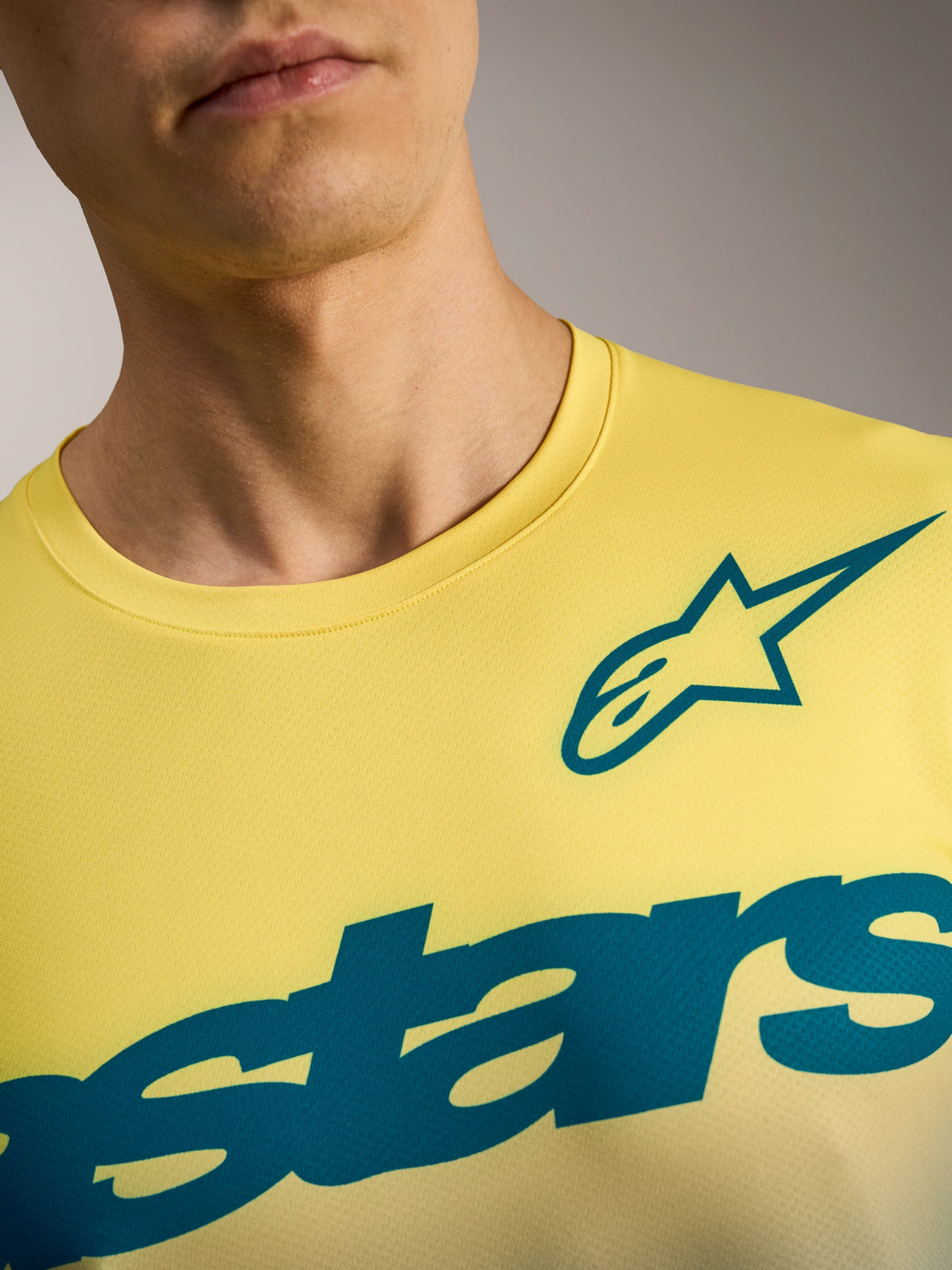Maillot Alpinestars A-Dura ASTARS 2.0 amarillo flúor, gráficos en azul verdoso, tejido técnico transpirable para MTB.