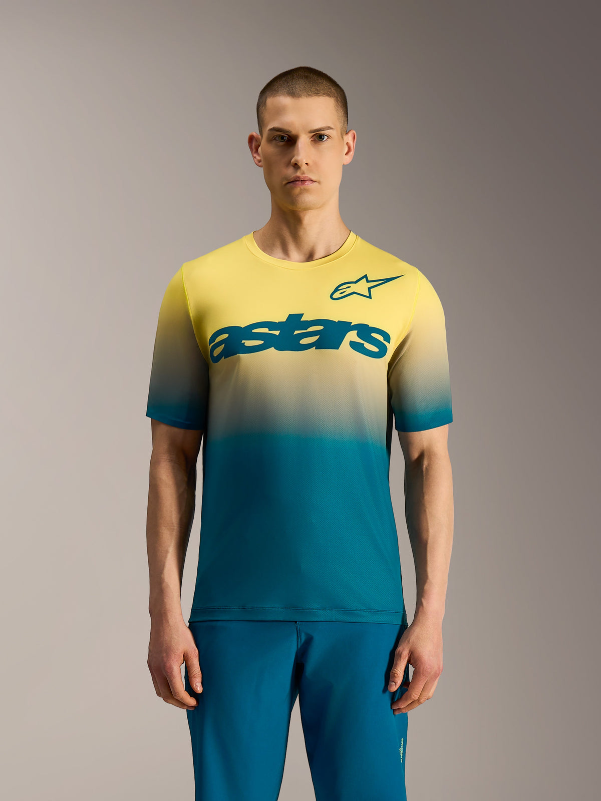 Maillot Alpinestars A-Dura ASTARS 2.0, camiseta MTB manga corta con degradado amarillo a azul verdoso y logo central