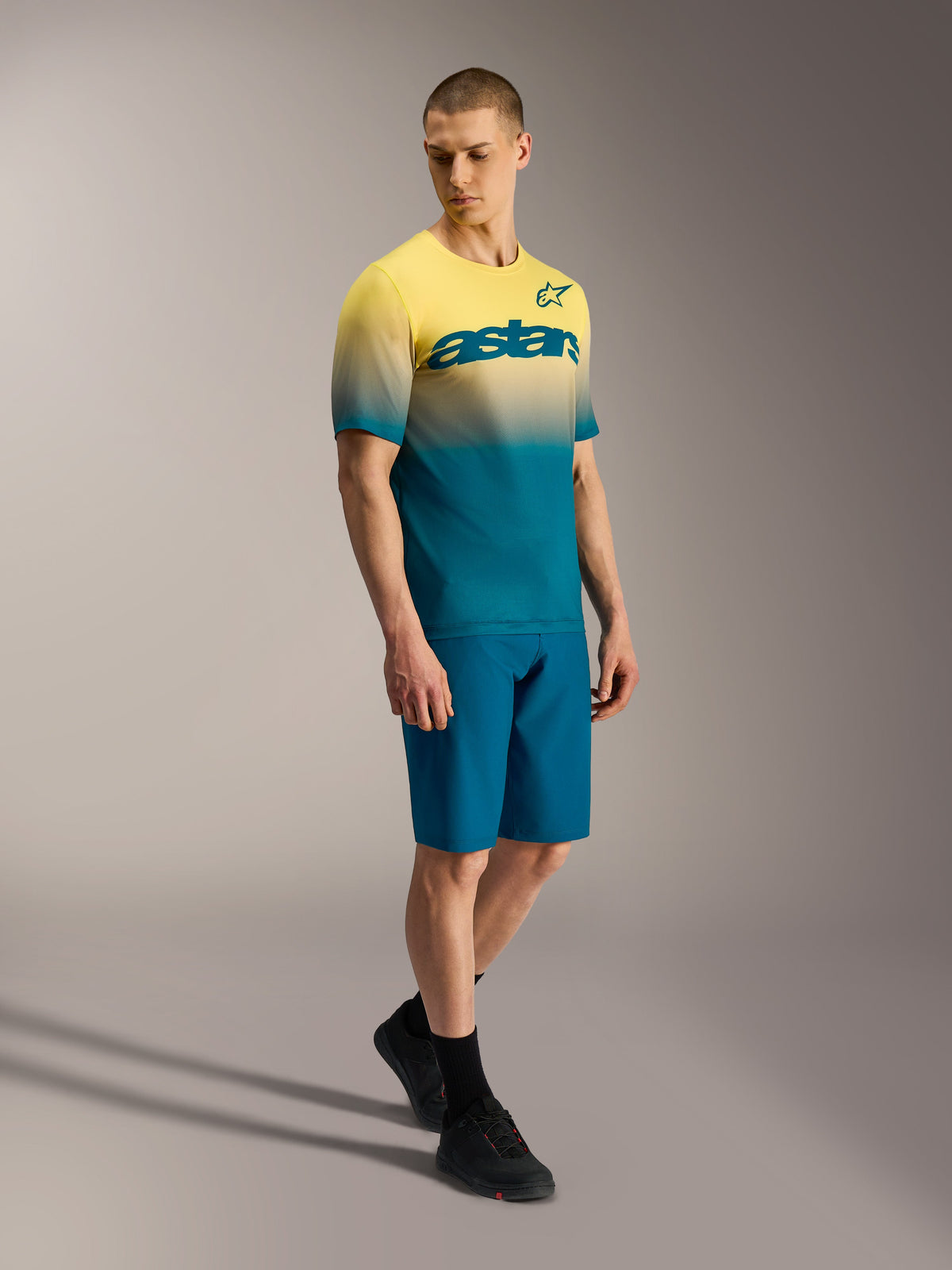 Maillot de MTB A-Dura ASTARS 2.0 con degradado amarillo a azul, manga corta y logo en el pecho sobre un modelo.