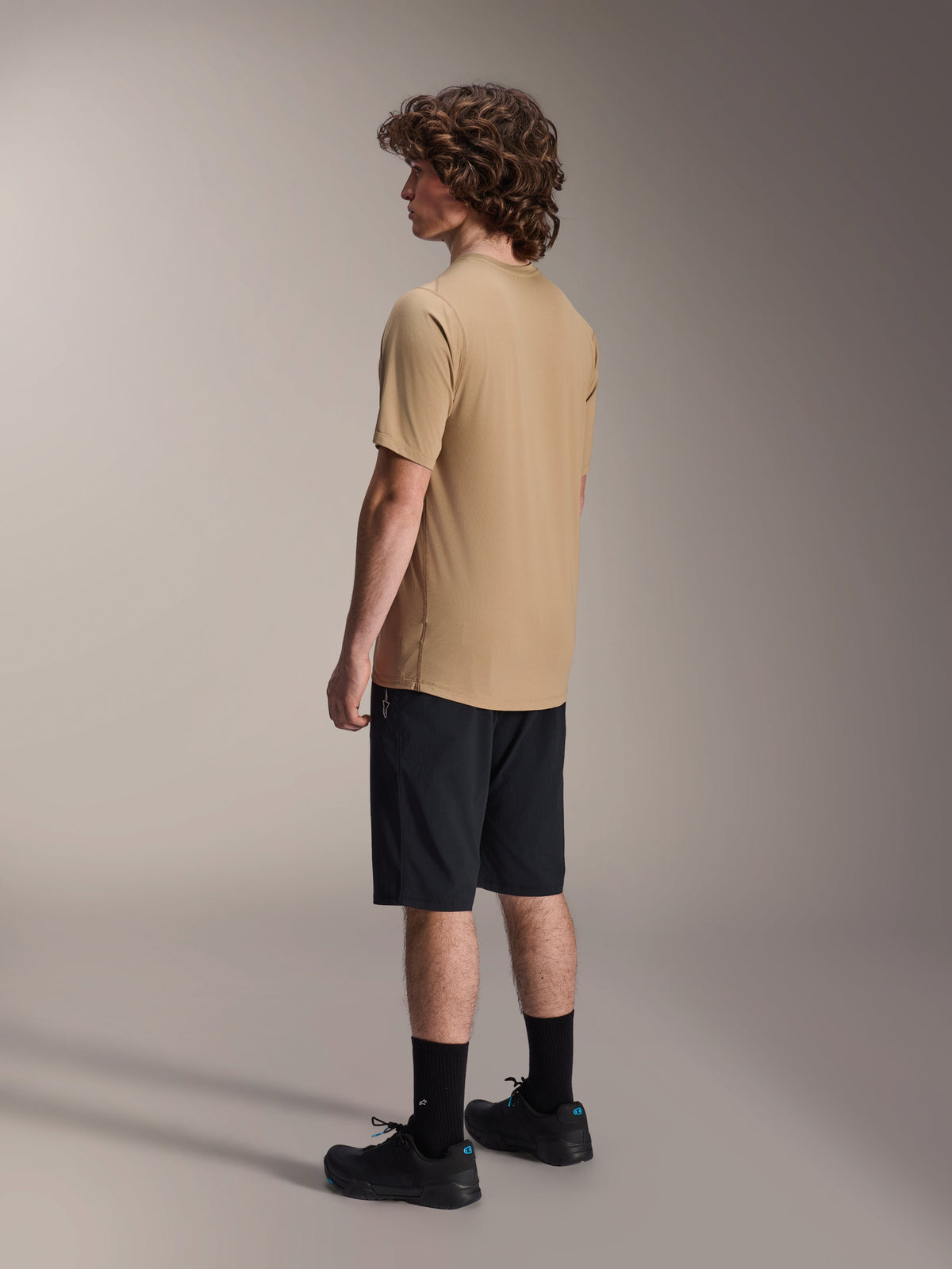 Jersey de manga corta Alpinestars A-Dura Astar, marrón claro, usado con pantalones cortos y calcetines negros, tejido jacquard transpirable que absorbe la humedad, ropa técnica casual para ciclismo de montaña