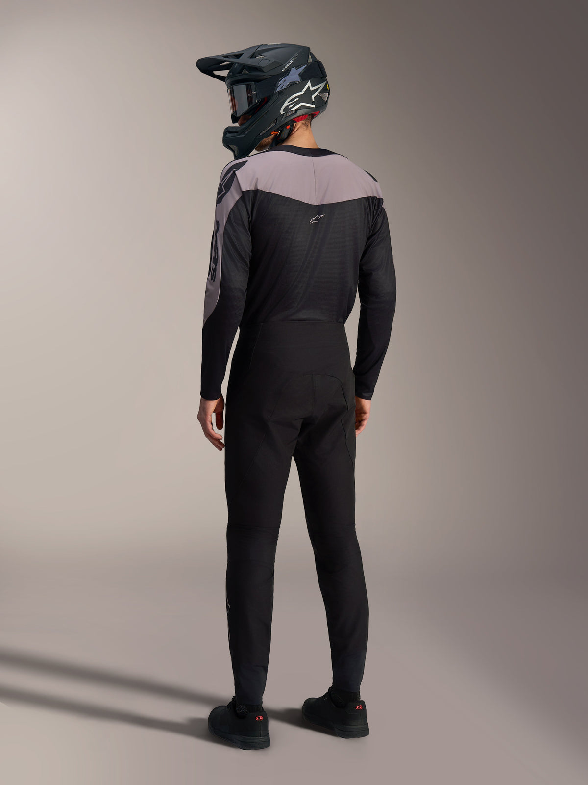 Kit Alpinestars A-Supra Elite MTB negro y gris, jersey de rendimiento y pantalones de carrera vistos desde atrás.