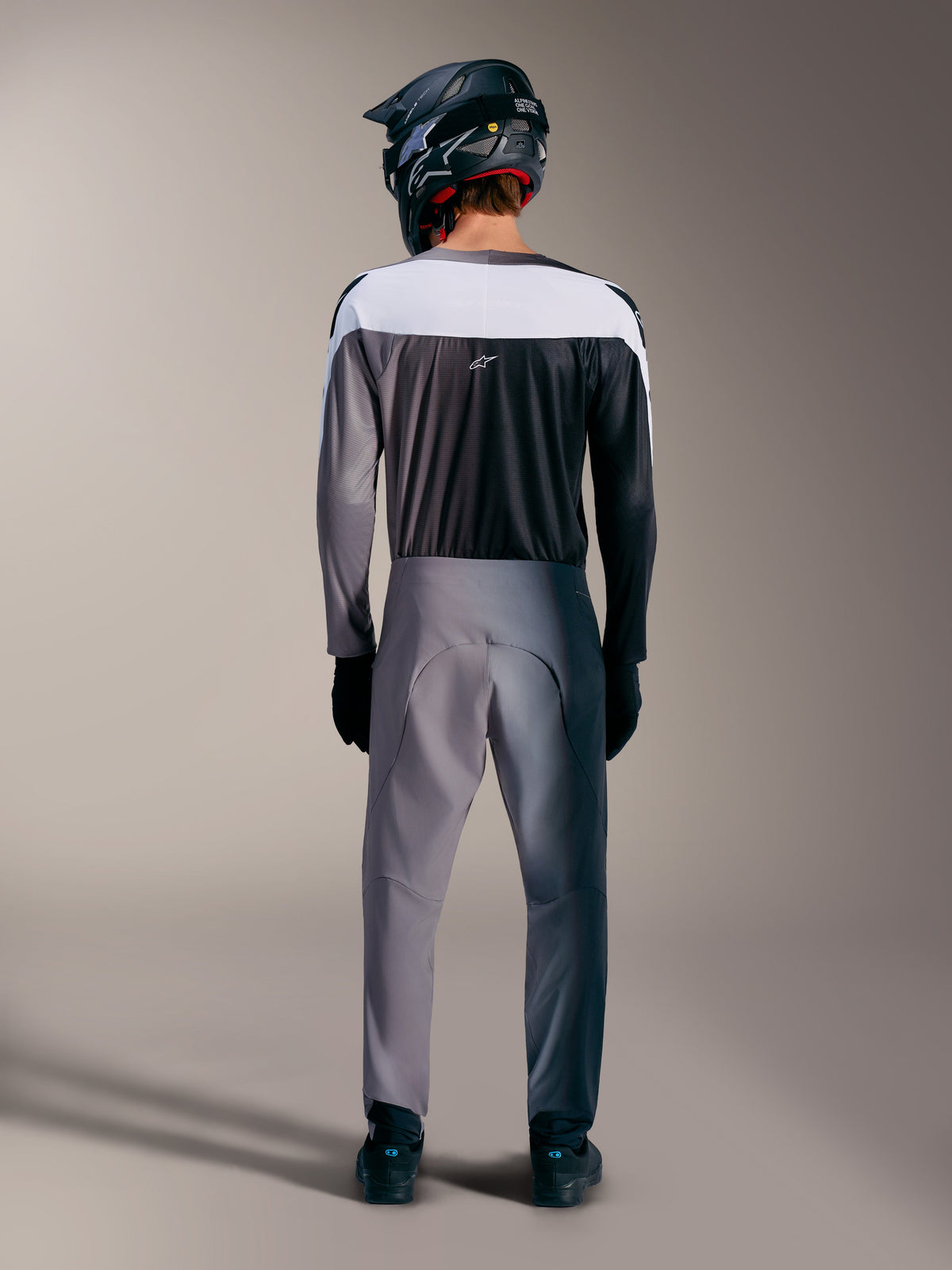 Jersey Alpinestars A-Supra Elite gris, vista trasera de equipación MTB con paneles de malla ventilada.