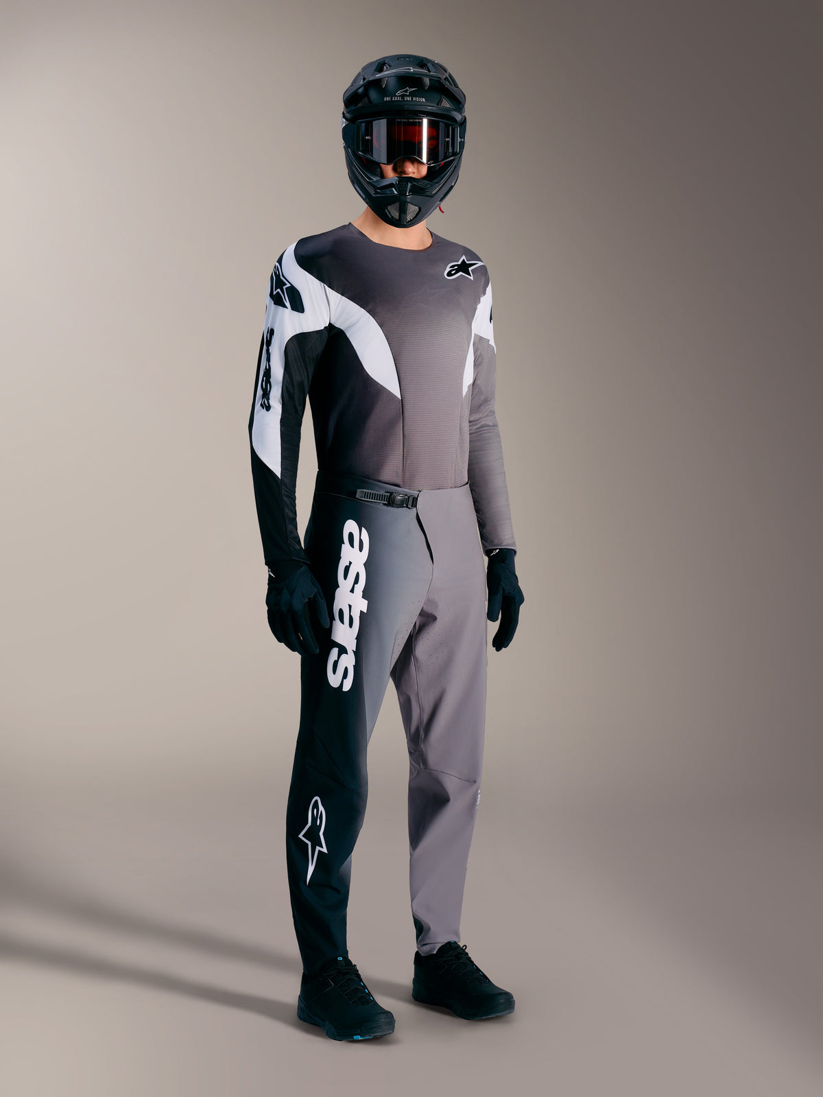 Maillot A-Supra Elite de manga larga para MTB en gris degradado con detalles en blanco y negro sobre piloto equipado.