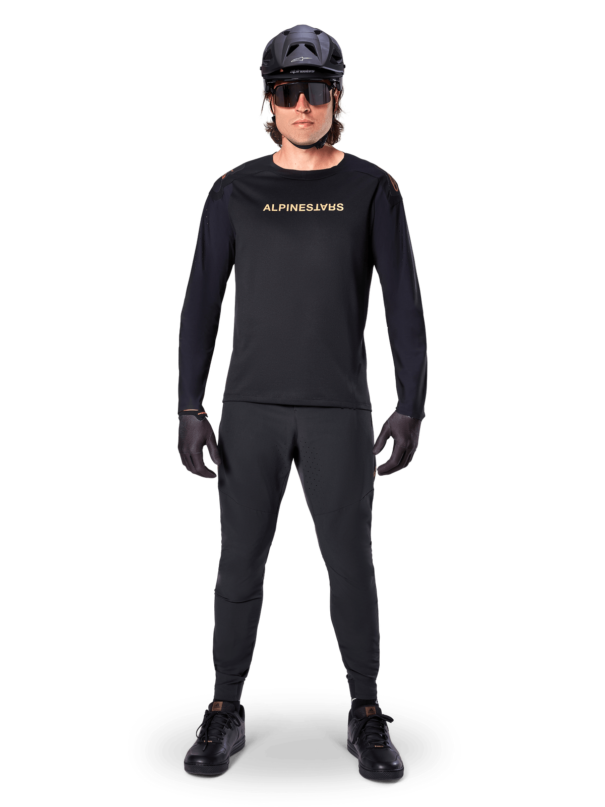 Alpinestars A-Aria Polartec Switch Long Sleeve Jersey, Black, worn by a rider with matching black technical pants, black helmet, sunglasses, and black gloves, performance MTB gear for off-road trails