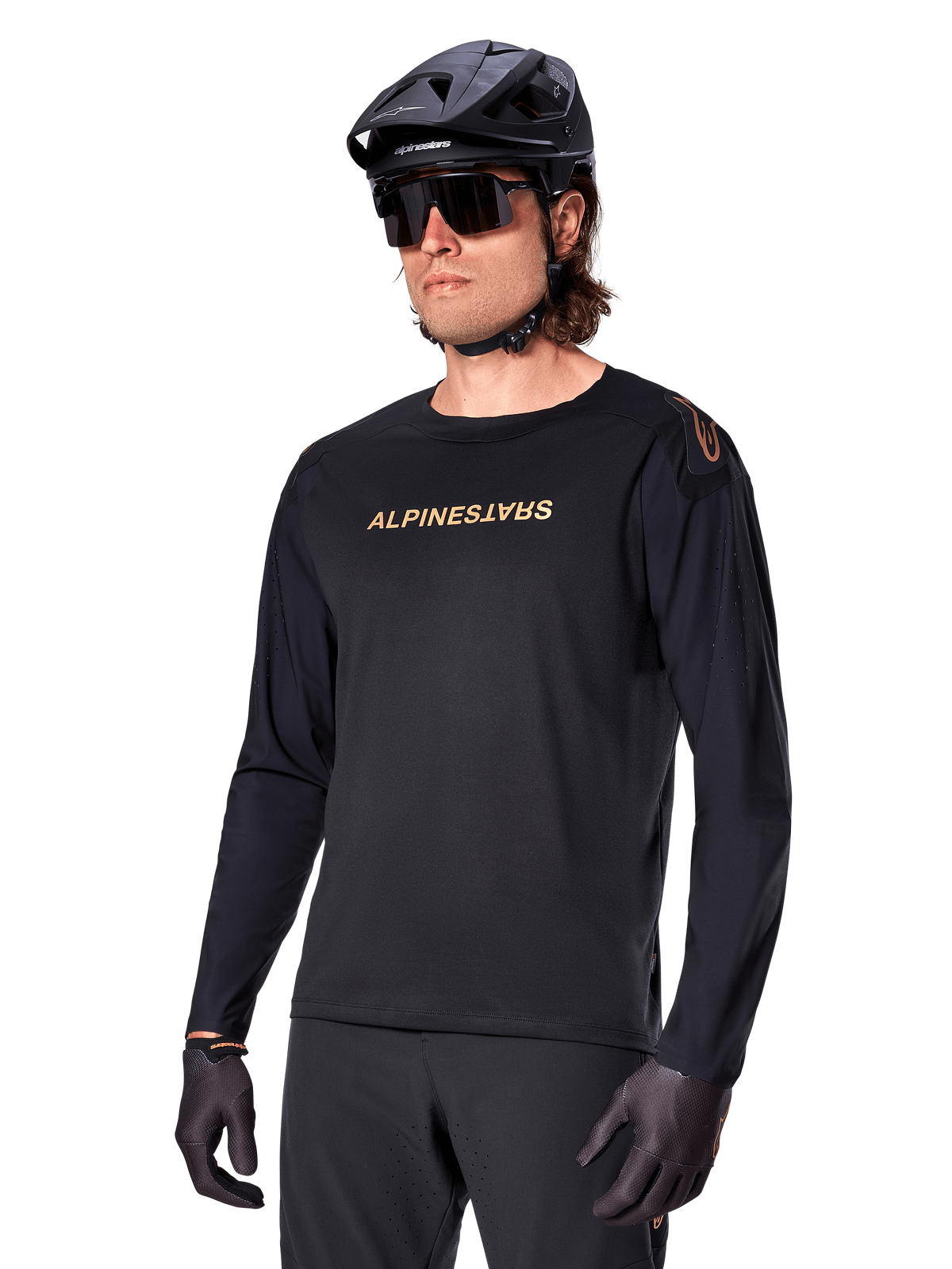 Alpinestars A-Aria Polartec Switch Long Sleeve Jersey, Black with gold logo, MTB mountain biking apparel, worn with a black helmet and sunglasses, featuring laser-cut ventilation on the sleeves and moisture-wicking Polartec fabric for off-road performance