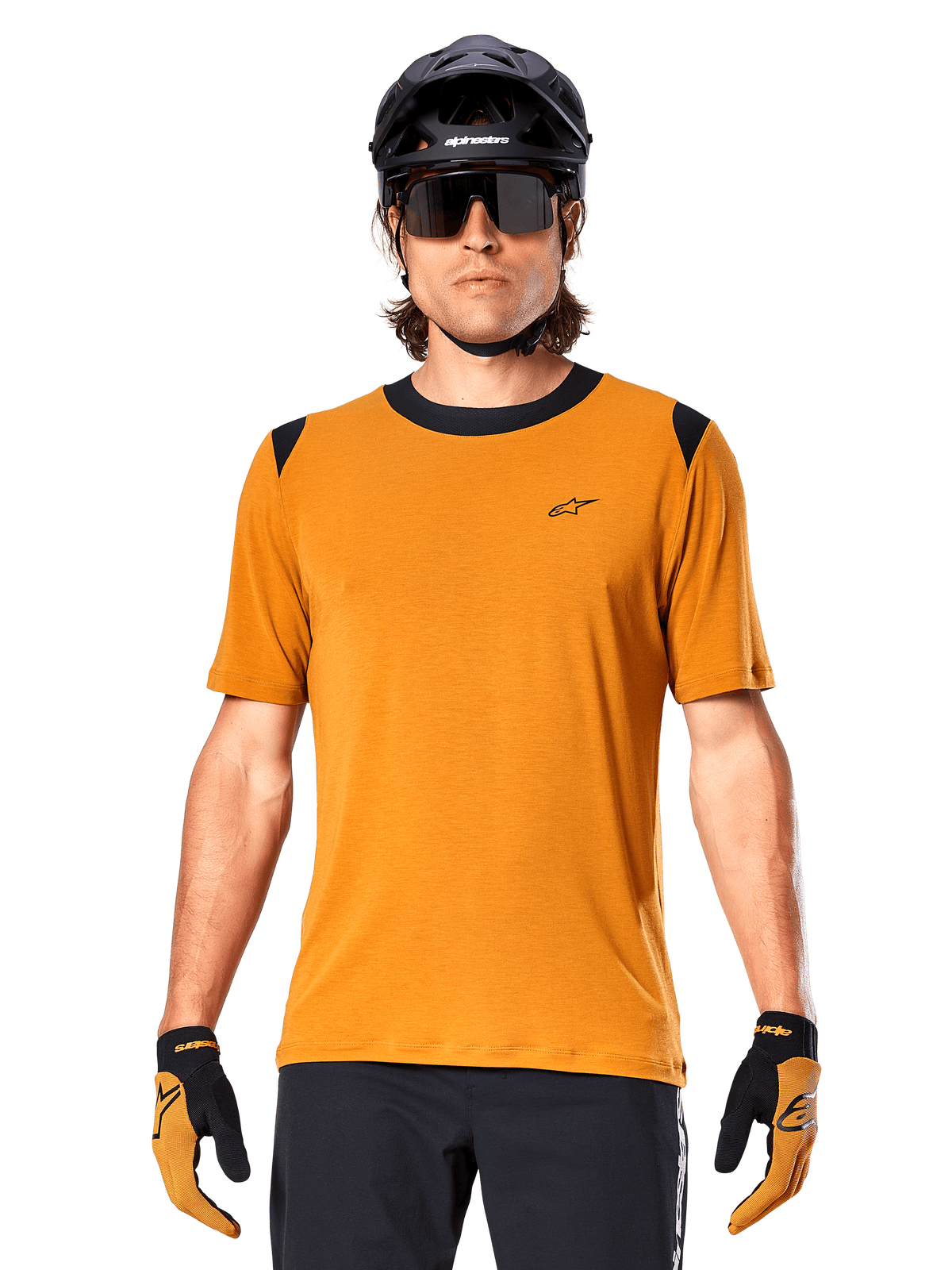 Camiseta de manga corta Alpinestars A-Dura Dri Wool, color oro oscuro, usada con casco de MTB negro, gafas de sol y guantes, con cuello y paneles en los hombros negros, mezcla de lana drirelease transpirable para ciclismo de montaña