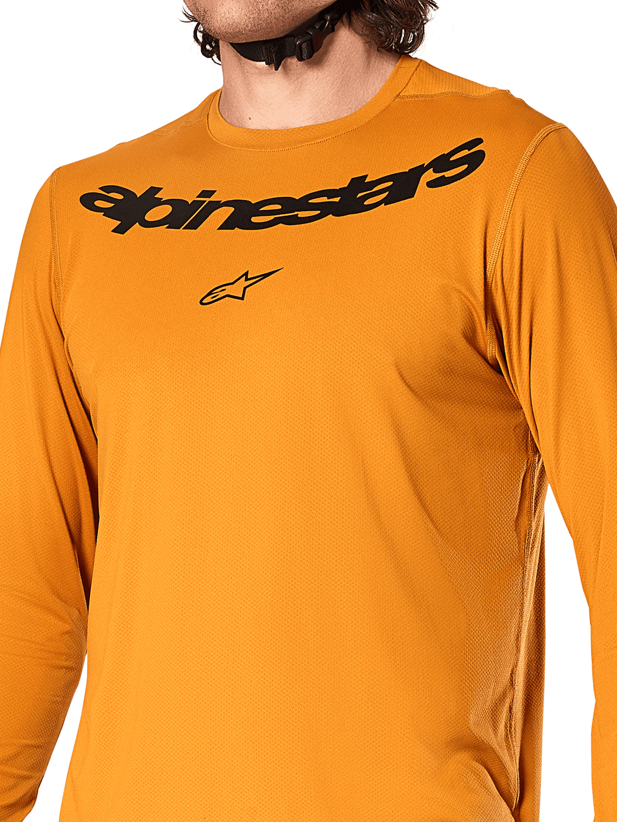 Camiseta de manga larga Alpinestars A-Dura Rocker, color Dark Gold, vista de primer plano del pecho con el logotipo y la marca Alpinestars en negro, tejido jacquard texturizado que absorbe la humedad, ropa técnica para ciclismo de montaña MTB
