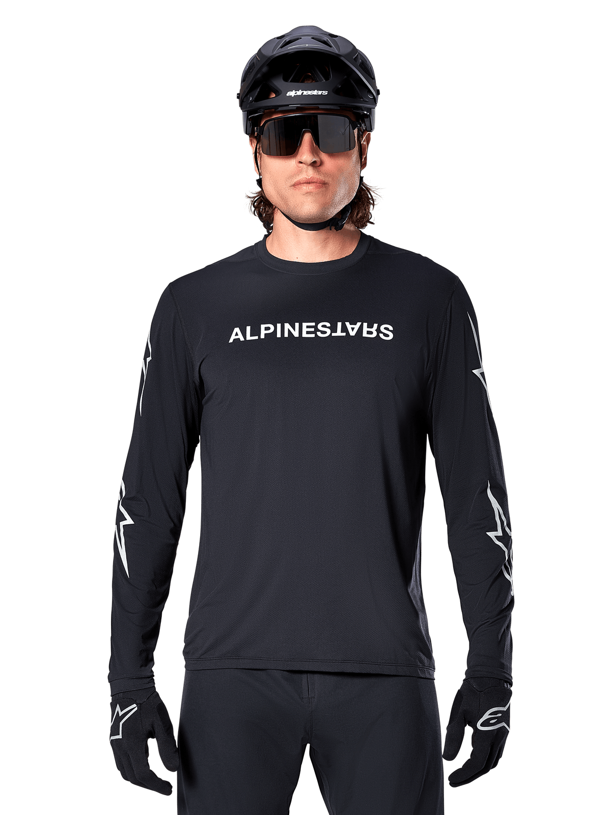 Alpinestars A-Dura Switch Long Sleeve Jersey, Black MTB jersey, white Alpinestars wordmark on chest and star graphics on the sleeves, worn with black mountain bike helmet and performance sunglasses, technical trail riding apparel