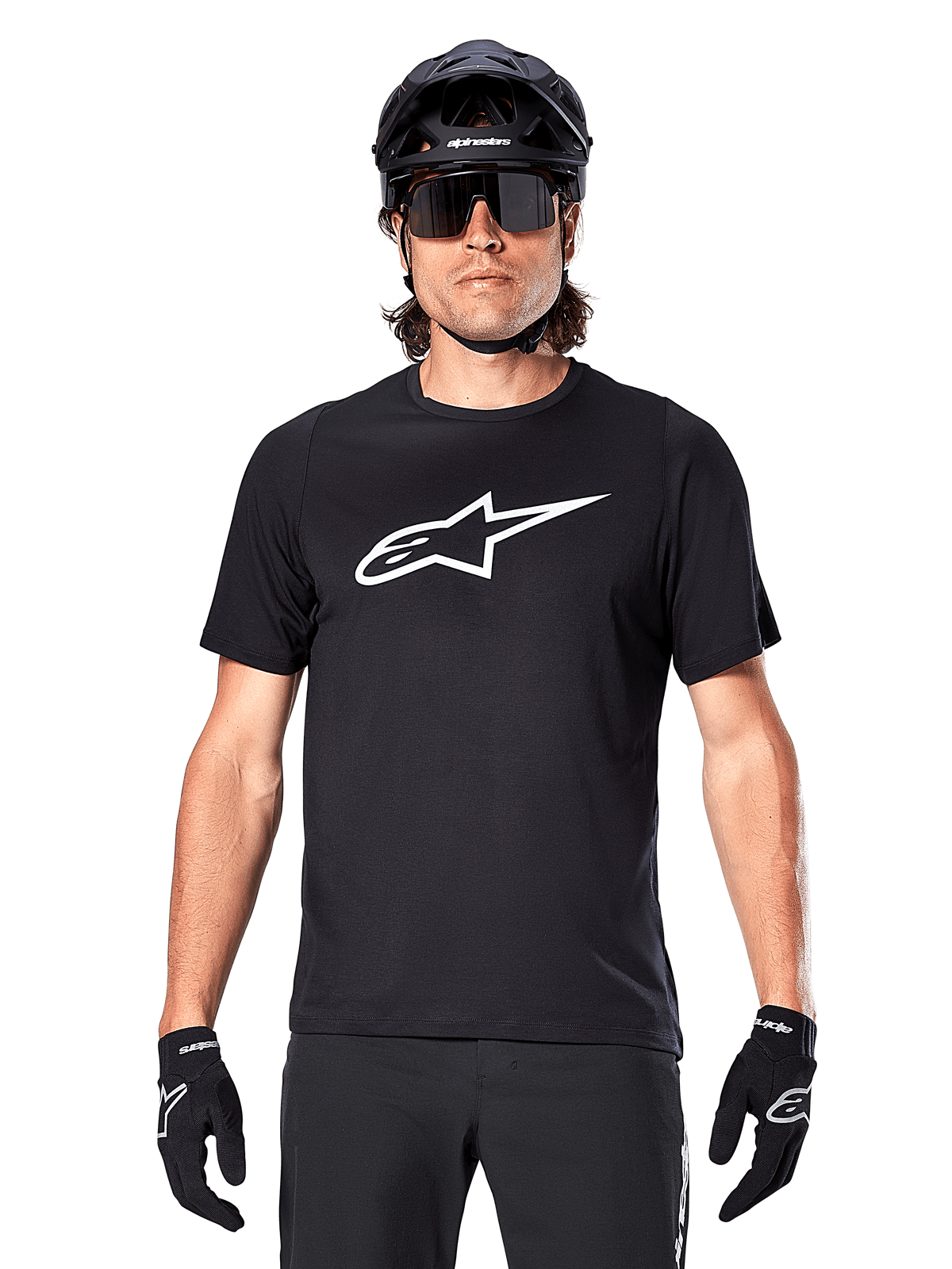 Alpinestars A-Dura Dri Oscar Jersey - Manga Corta, negro reflectante, usado con casco de MTB negro, gafas de sol y guantes, con un logotipo blanco prominente en el pecho, equipamiento de alto rendimiento para ciclismo de montaña