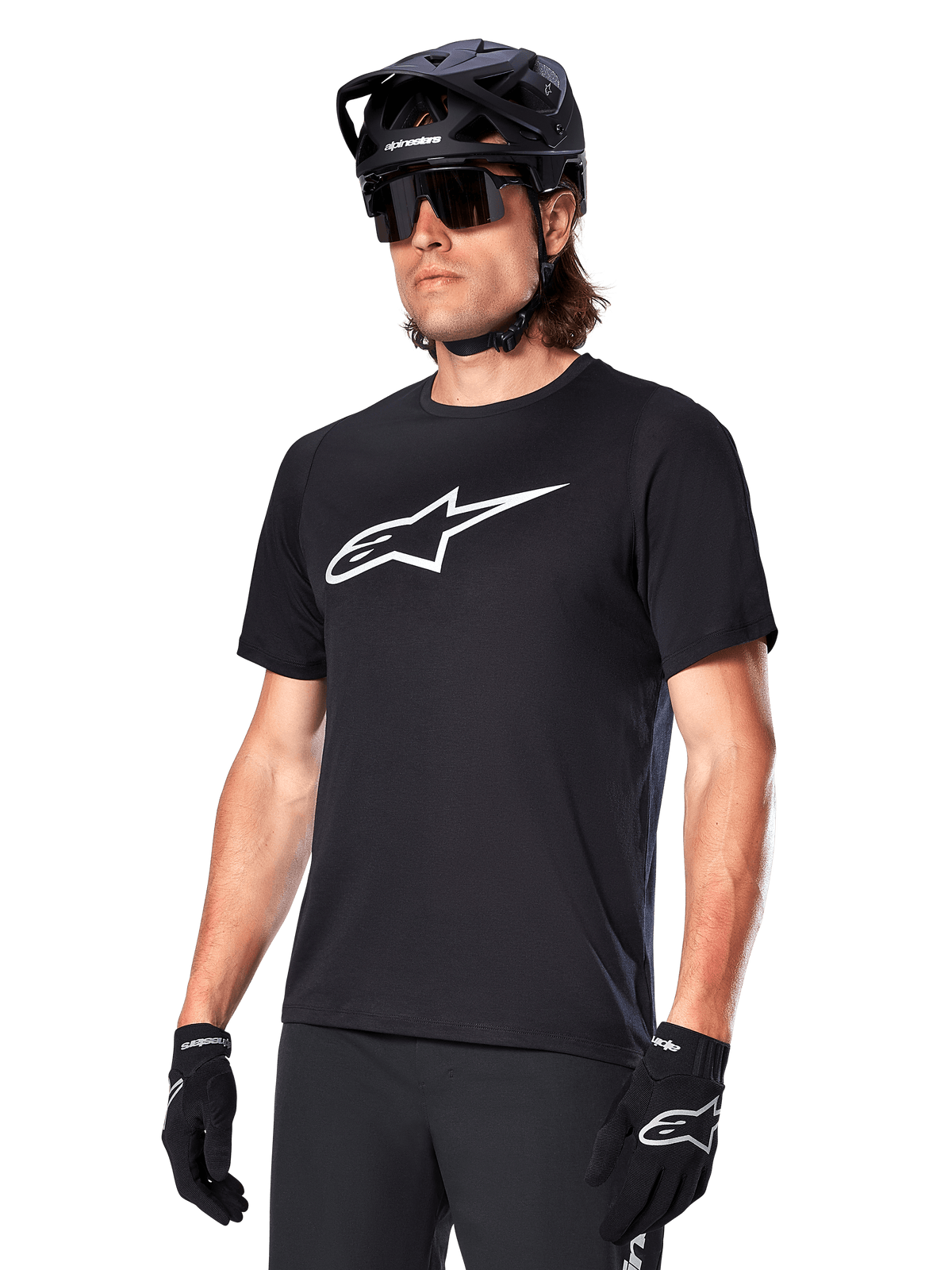 Alpinestars A-Dura Dri Oscar Jersey, camiseta de ciclismo MTB de manga corta, negra con logotipo blanco, tejido técnico transpirable, usada con casco negro, gafas de sol y guantes