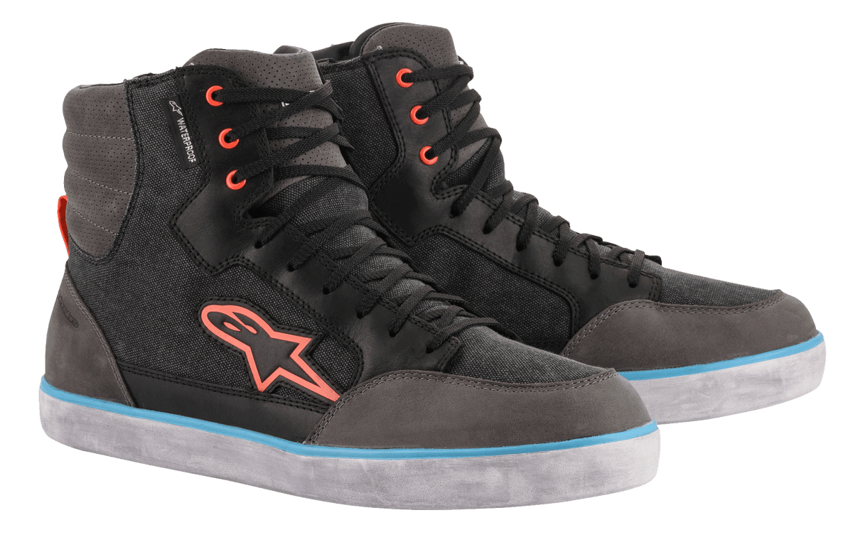 Alpinestars J-6 Waterproof Canvas Riding Shoes, negro y gris antracita, diseño de zapatilla de caña alta con logotipo y ojales naranjas, franja azul claro en la suela blanca, calzado urbano impermeable para motocicleta
