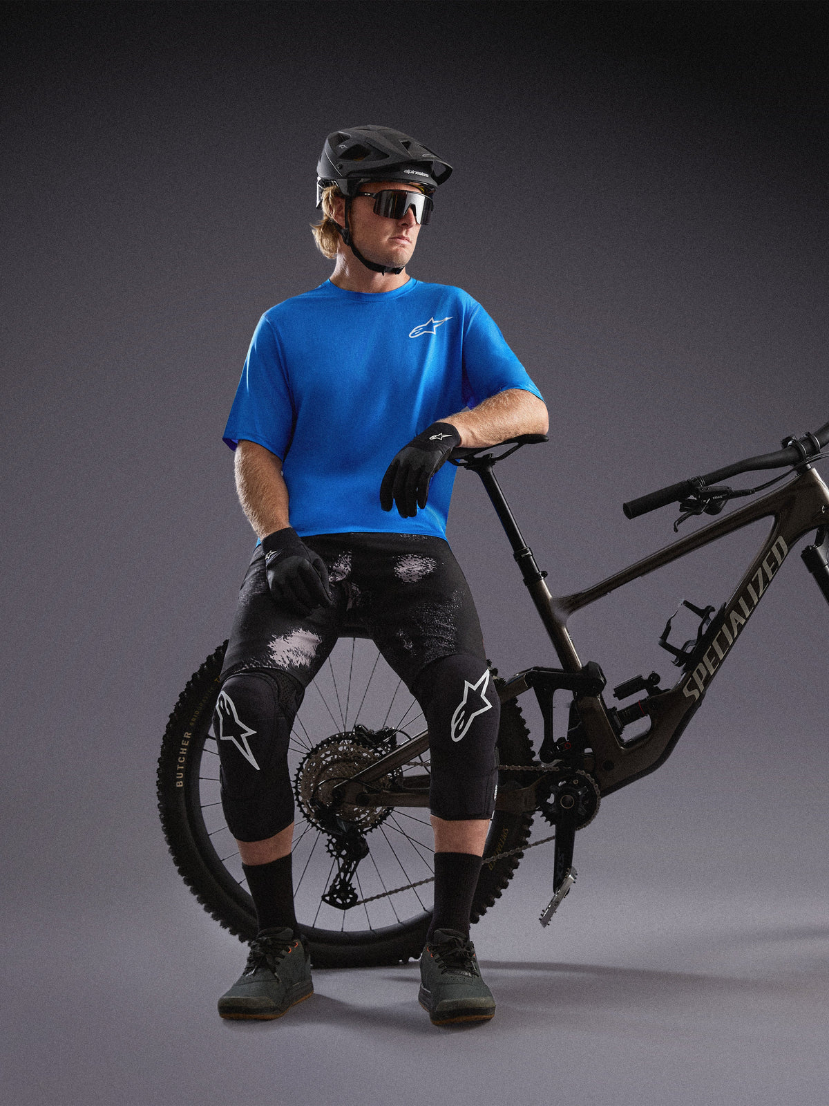 Jersey Alpinestars A-Dura Air SS azul y shorts Black Camo en ciclista con bicicleta de montaña en un estudio.