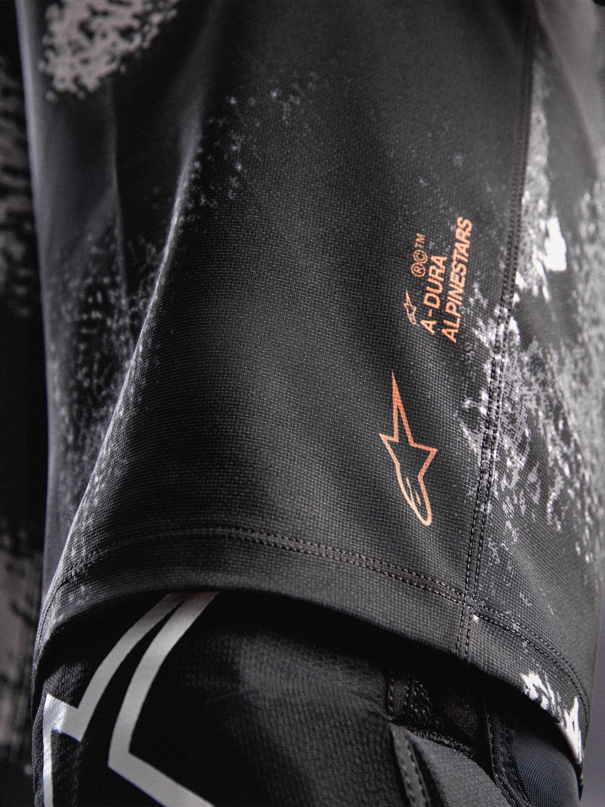 Pantalones cortos A-Dura Ride en camuflaje negro con logotipo naranja Alpinestars y tejido elástico duradero para MTB.