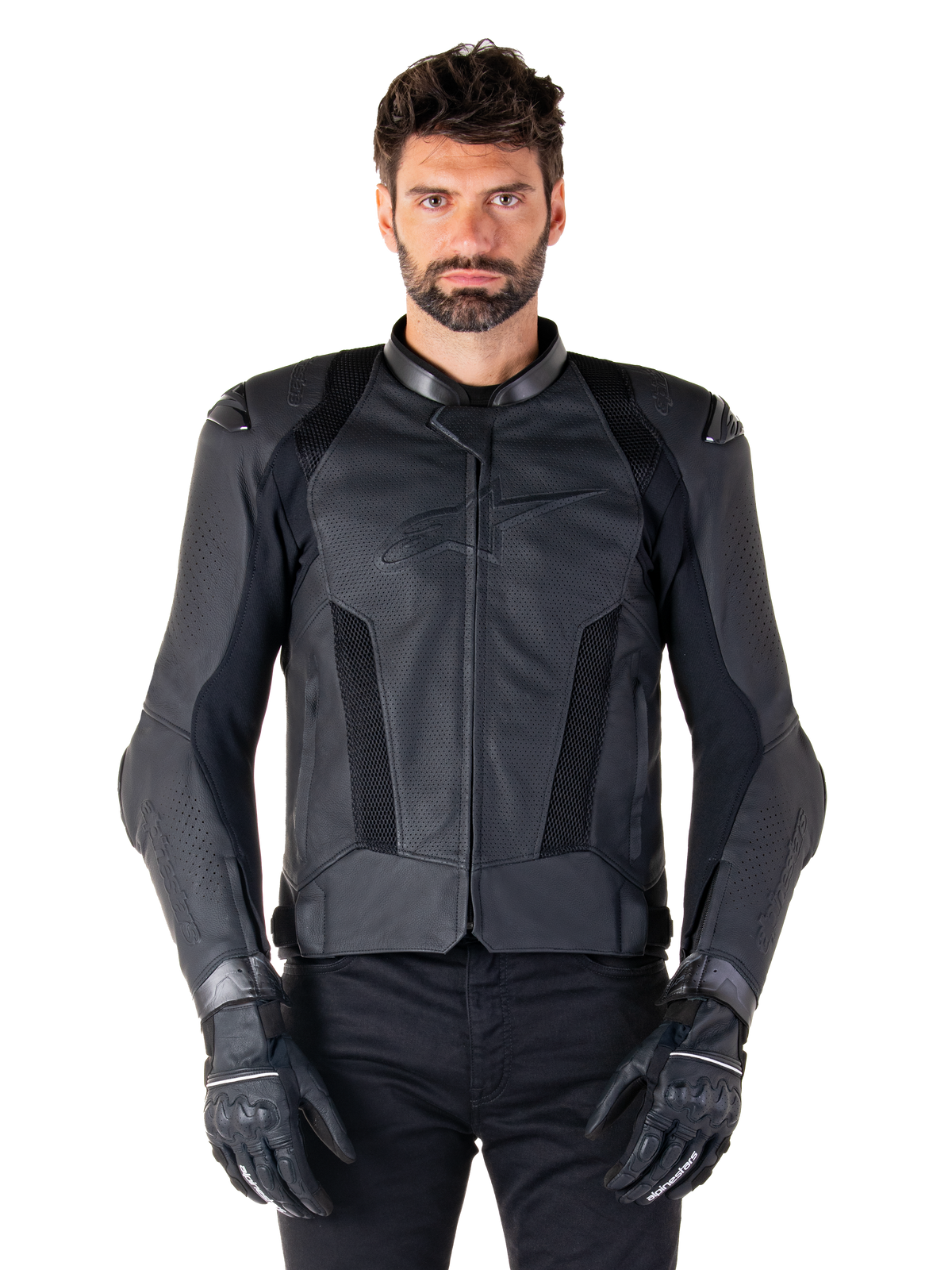 Alpinestars Missile V3 Airflow Leather Jacket, negra, chaqueta de moto de competición, llevada por un modelo con guantes y pantalones negros, con paneles de cuero perforado, ventilación de malla y protectores de hombros externos, confección en cuero premium para conducción deportiva.