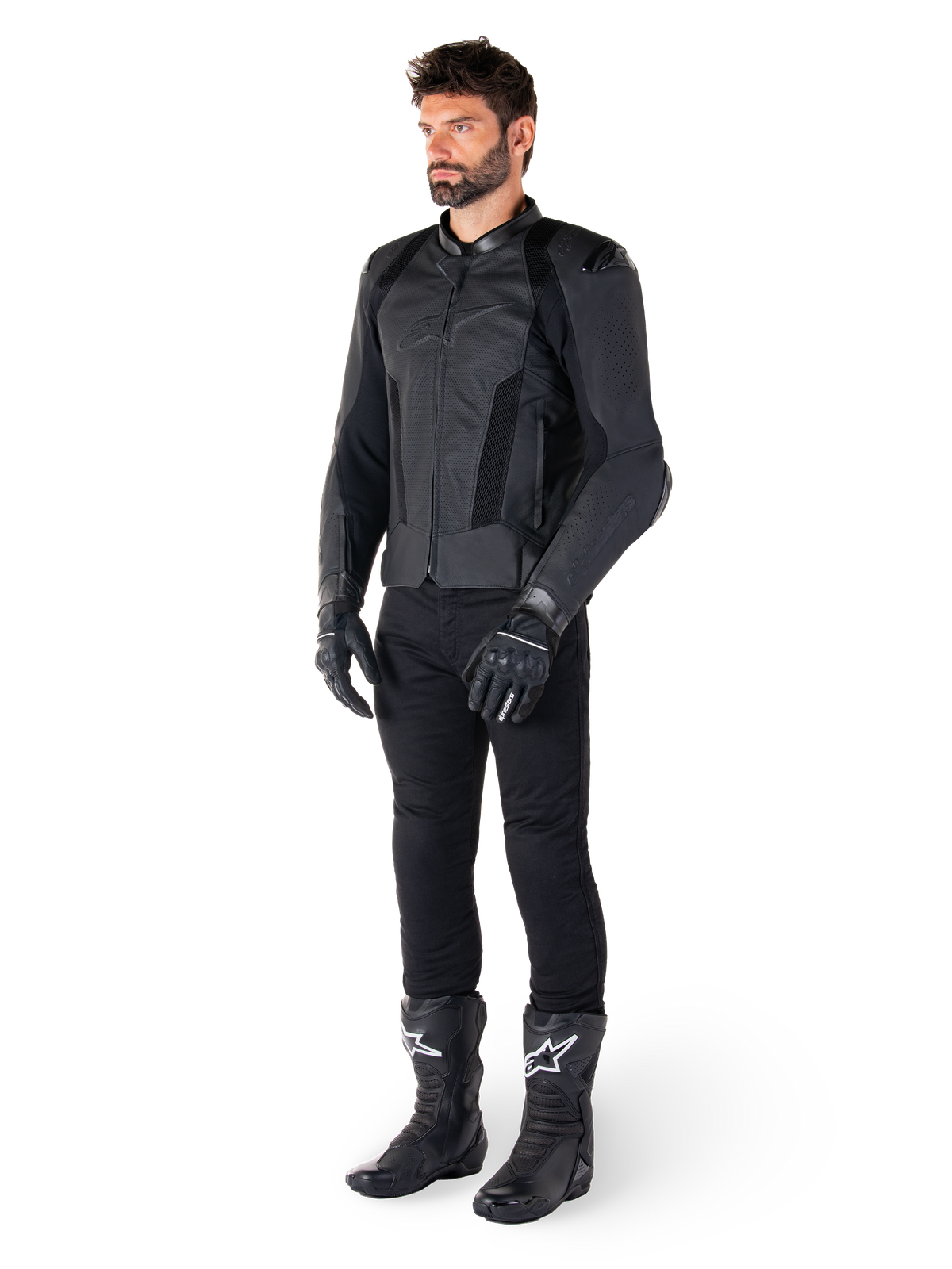 Chaqueta de cuero Alpinestars Missile V3 Airflow, negra, usada por un piloto con pantalones, guantes y botas negros a juego, con cuero bovino perforado para una máxima ventilación y protección DFS en los hombros, equipamiento deportivo de moto premium