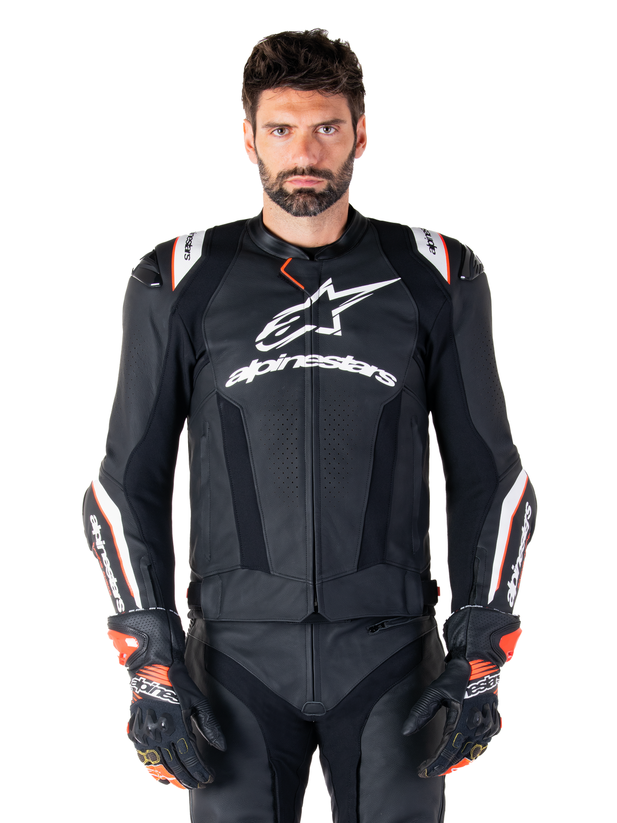 Chaqueta de cuero Alpinestars Missile V3 Ignition, negra con detalles en blanco y rojo, lucida por un modelo masculino con guantes y pantalones de carreras a juego, chaqueta deportiva de motociclismo derivada de MotoGP con logotipos llamativos