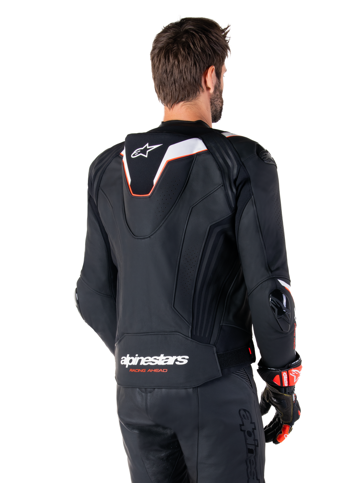 Chaqueta de cuero Alpinestars Missile V3 Ignition, vista trasera, negra con detalles en blanco y rojo, con joroba aerodinámica deportiva y logotipos de Alpinestars, usada con pantalones de cuero a juego y guantes de carreras