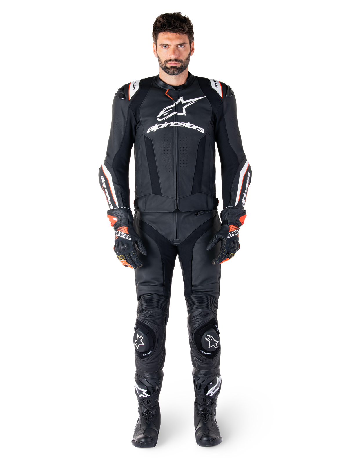 Piloto masculino con la chaqueta de cuero Alpinestars Missile V3 Ignition en color negro, combinada con pantalones de cuero, guantes y botas a juego, con logotipos blancos de Alpinestars y detalles en rojo, diseñada para un rendimiento de competición profesional.
