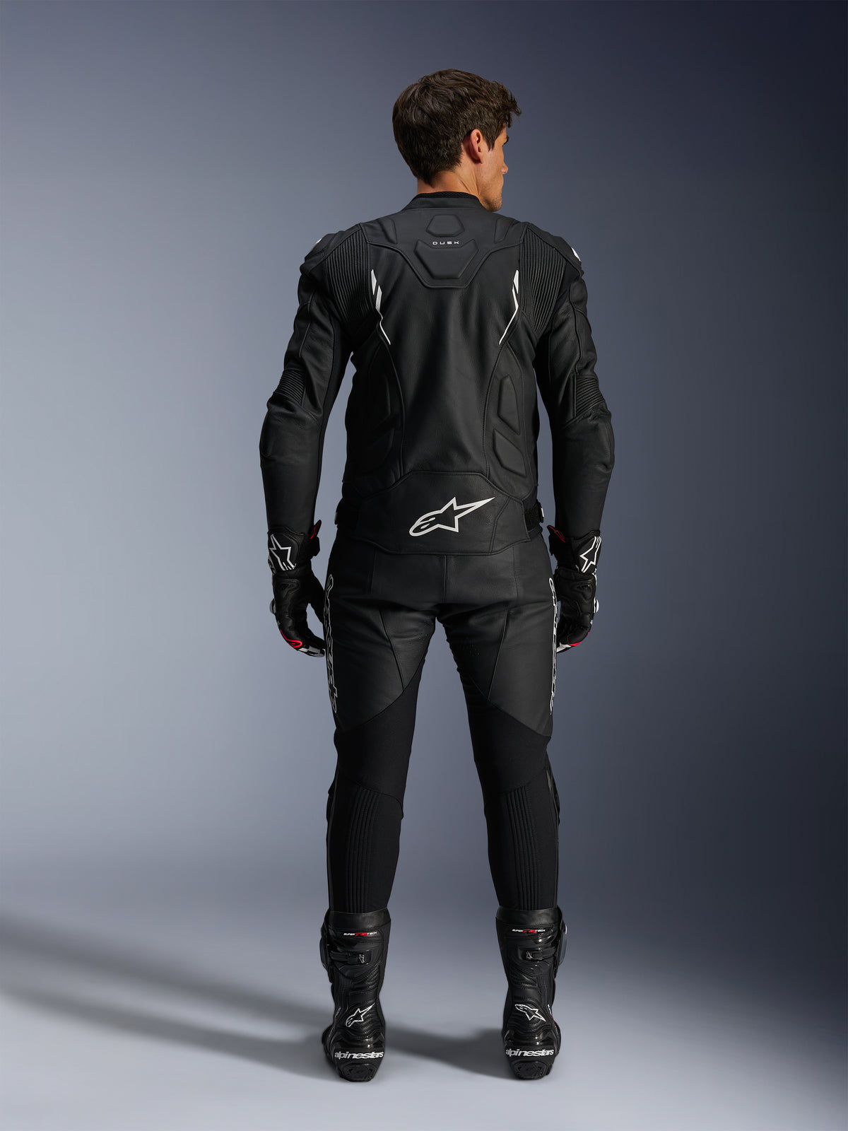 Chaqueta de cuero Alpinestars Dusk y pantalones Missile V3, mono de carreras negro y blanco para hombre, vista trasera.