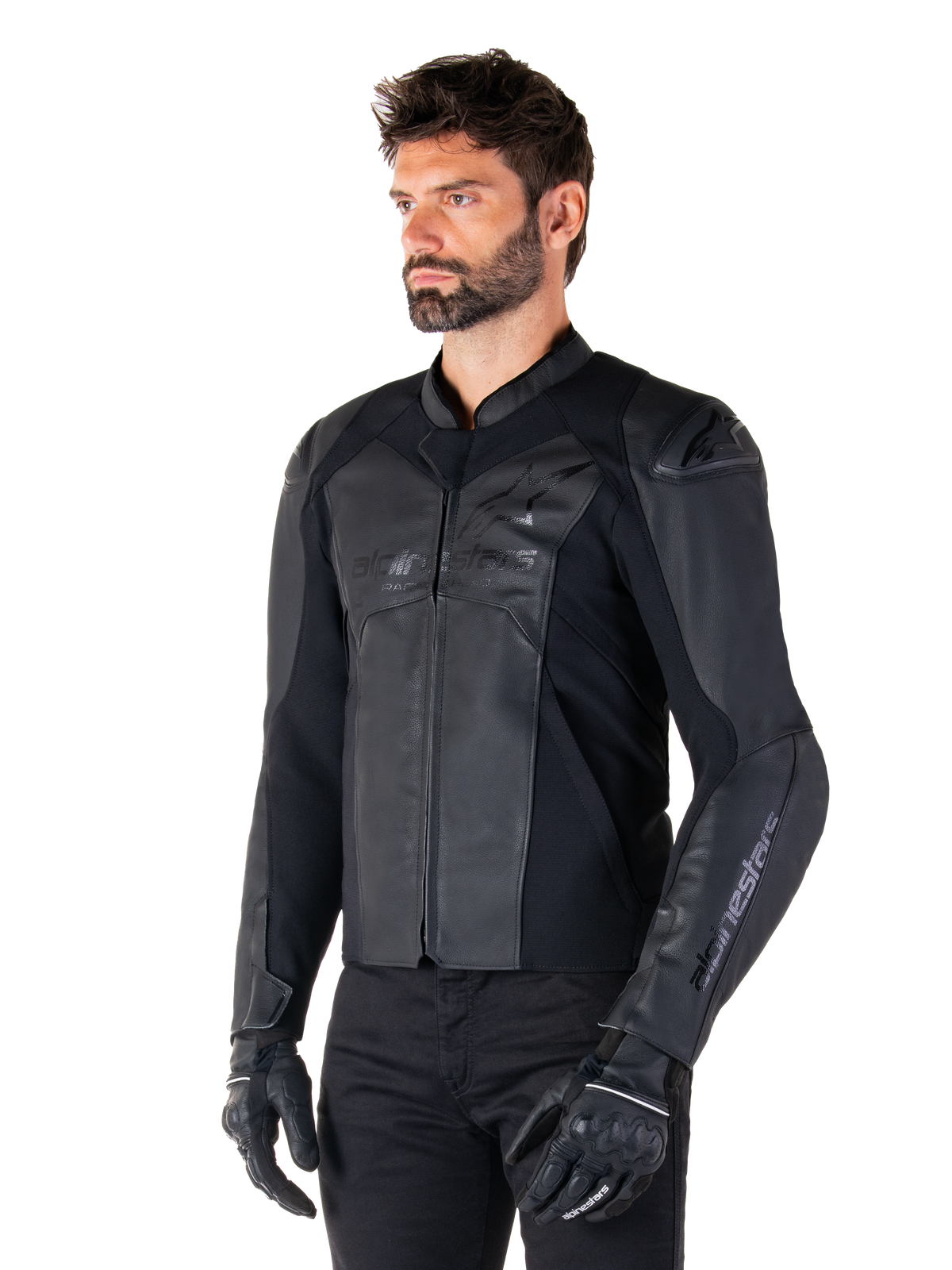 Alpinestars Faster V3 Leather Jacket, chaqueta de conducción deportiva, negro, usada por un modelo masculino con pantalones y guantes negros, confección en cuero de primera calidad con paneles elásticos y protectores de hombros DFS GP Lite, silueta deportiva elegante y moderna