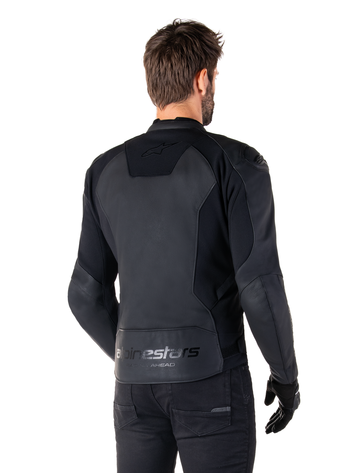 Chaqueta de cuero Alpinestars Faster V3, Negro Negro, vista trasera del modelo con la chaqueta de conducción deportiva, con la marca 'alpinestars' y 'RACING AHEAD' en la parte inferior de la espalda, cuero premium con paneles mate, silueta deportiva moderna para la conducción de motocicletas