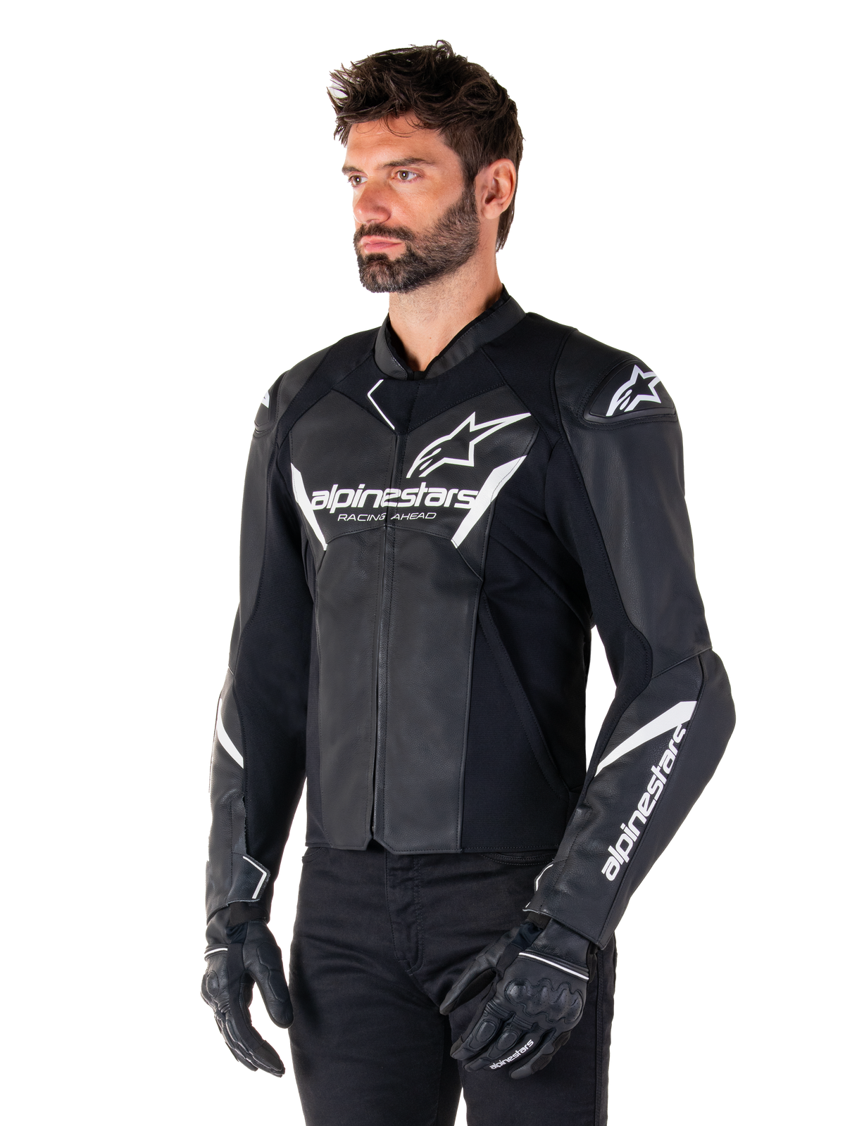 Chaqueta de cuero Alpinestars Faster V3, chaqueta de moto deportiva, negro y blanco, con un prominente logo blanco de Alpinestars y el texto 'Racing Ahead' en el pecho, logos de estrella en los hombros, construcción de cuero premium con paneles elásticos, vestida por un modelo con pantalones y guantes negros
