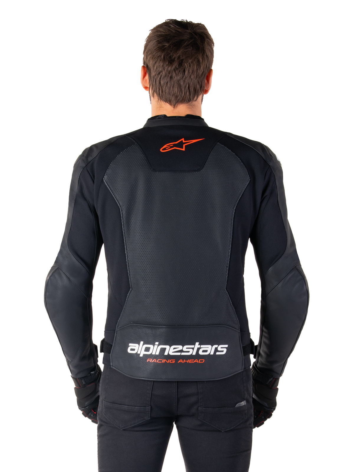 Chaqueta de cuero Alpinestars Faster V3 Airflow, negra, vista trasera con paneles de cuero perforado para ventilación, logo de la estrella de Alpinestars en rojo y marca en blanco en la parte inferior de la espalda, combinada con pantalones y guantes negros.
