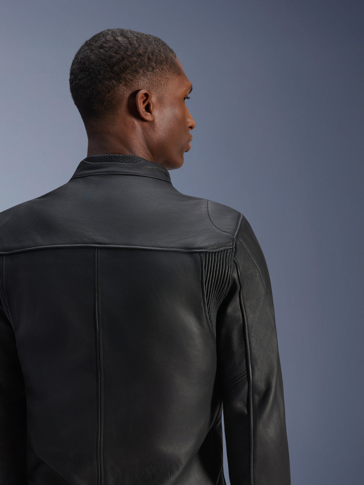 Alpinestars Blacktrack, chaqueta de cuero para moto de hombre, negra, vista trasera con paneles de acordeón y cuello perforado para conducción urbana
