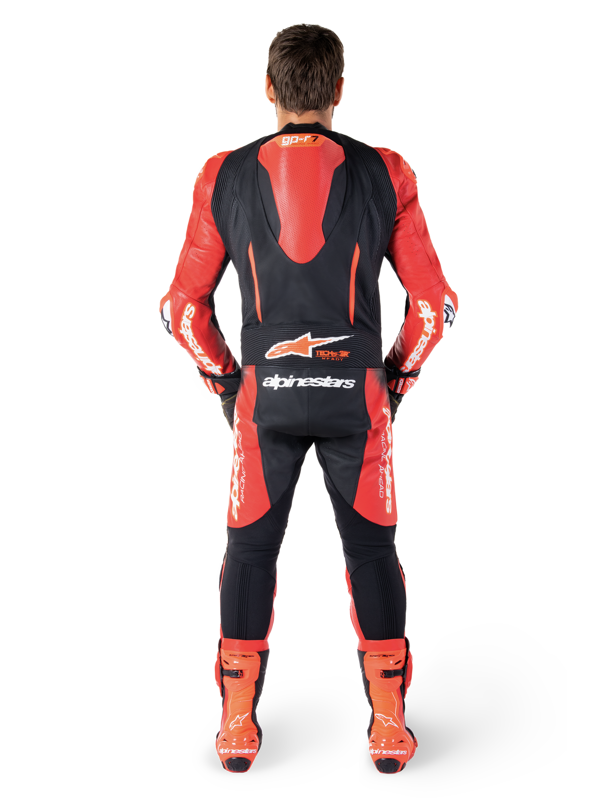 Alpinestars GP-R7, mono de cuero de una pieza para carreras, negro y rojo, vista trasera con joroba aerodinámica, logotipo Tech-Air Ready y botas rojas.