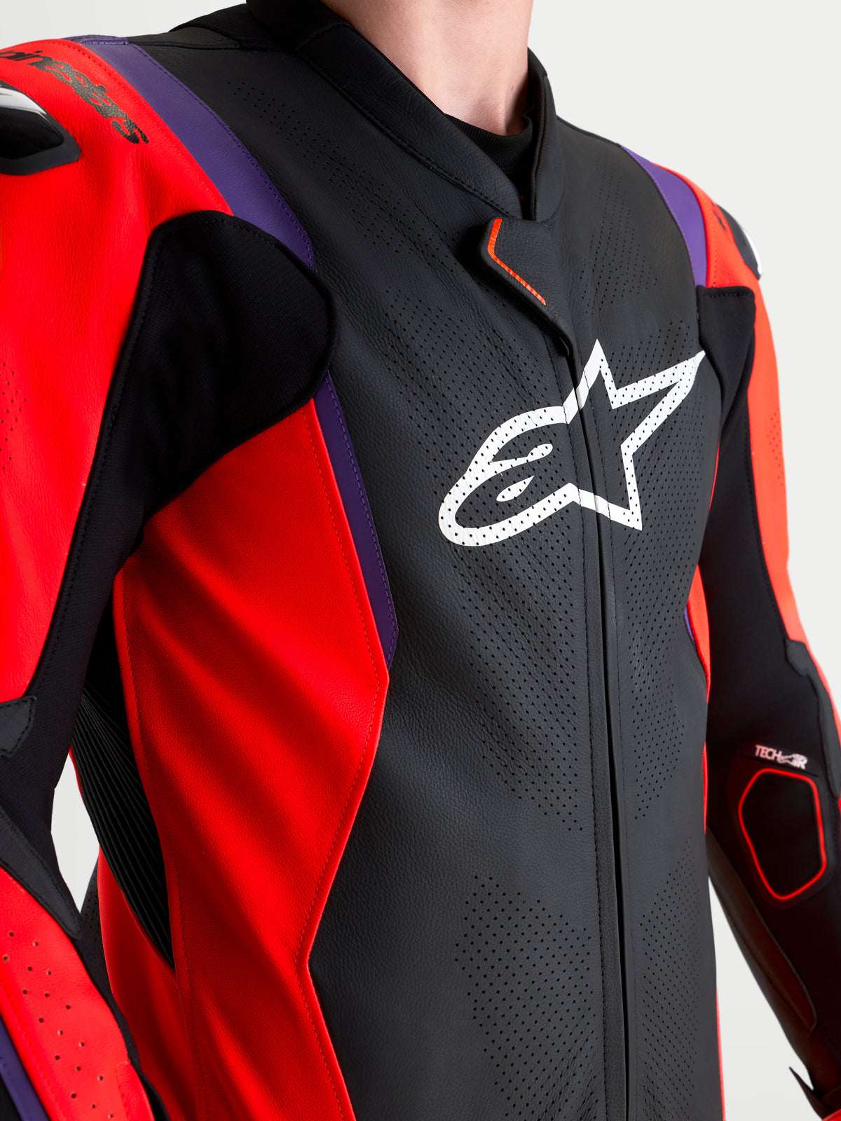 Alpinestars Missile V3 Leather Suit 1 Pc, mono de cuero de una pieza para competición, negro, rojo y morado, vista detallada del pecho con logo Astar blanco