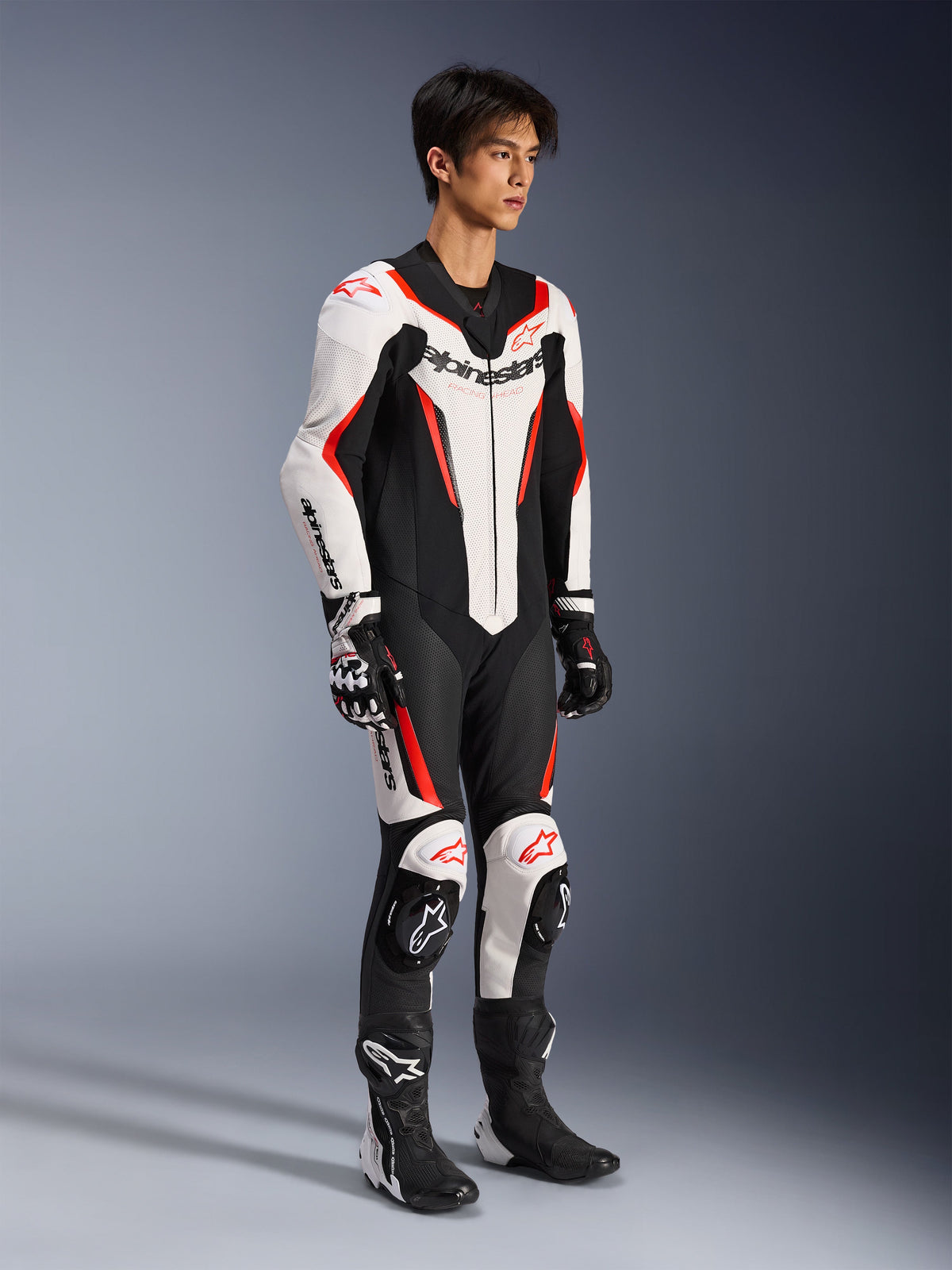 Alpinestars GP Force V2 Leather Suit - 1Piece, mono de competición de una pieza para motocicleta, blanco, negro y rojo flúor, combinado con guantes y botas a juego, con cuero perforado y logotipos destacados de Alpinestars, diseño aerodinámico para rendimiento en pista