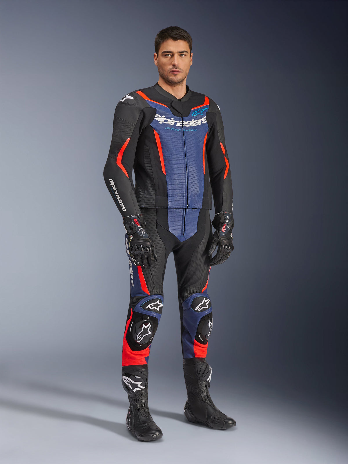 Traje de cuero de 2 piezas Alpinestars GP Force V2, traje de cuero para motocicleta, negro, azul y rojo flúor, usado con guantes y botas de carreras negros a juego, con paneles perforados y deslizadores protectores, diseño aerodinámico para conducción deportiva