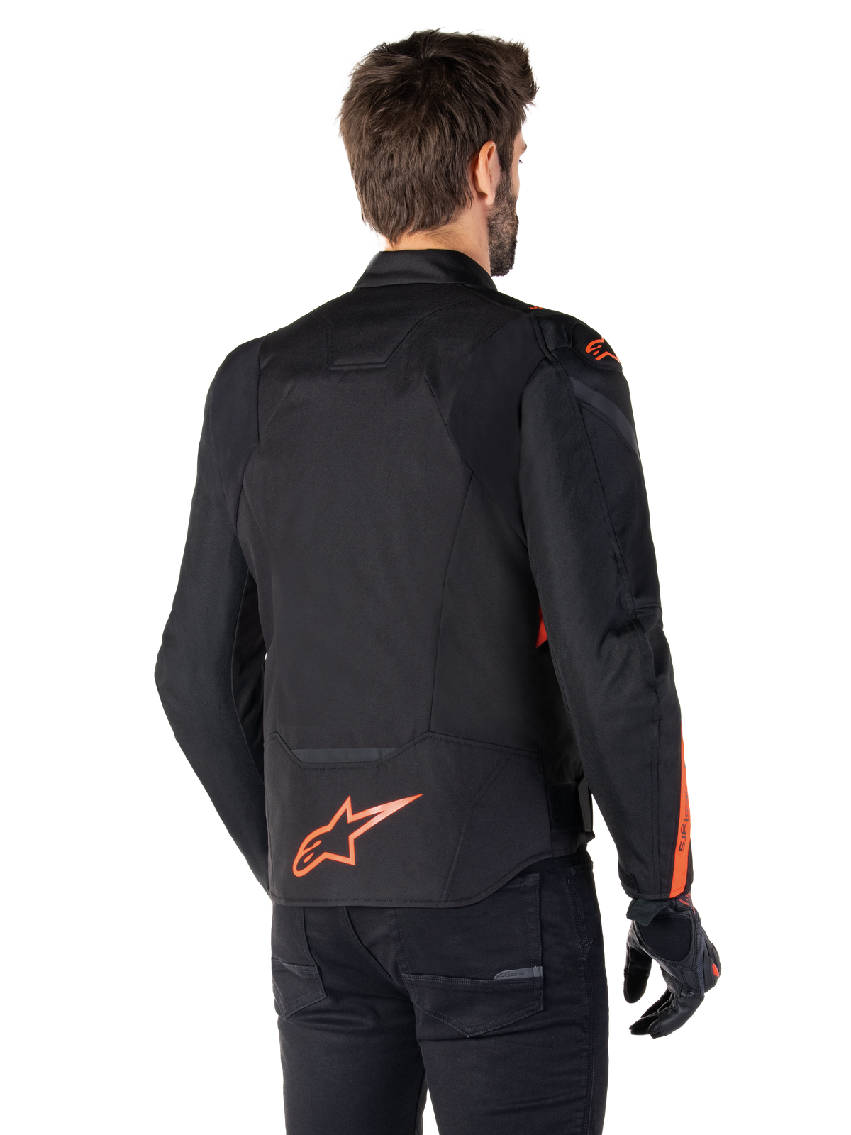 Male model wearing the Alpinestars T-Jaws V4 Waterproof Jacket from the back, Black with Red Fluo accents, featuring a red fluo logo on the lower back and accents on the shoulders and sleeves, sport motorcycle riding gear.