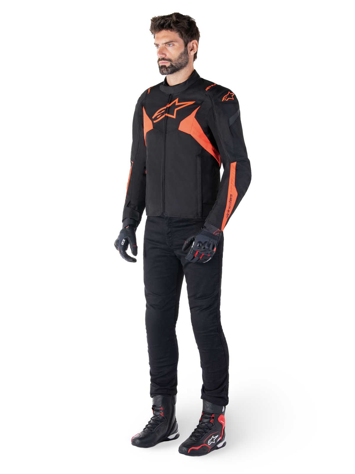 Alpinestars T-Jaws V4 Waterproof Jacket, Black and Red Fluo, worn by a male model with black pants, gloves, and boots, featuring bright orange accents and the Alpinestars logo, sporty design for motorcycle riding