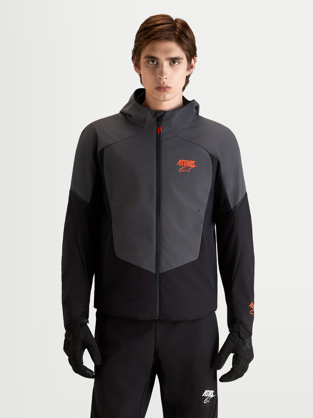 Alpinestars Aeroshell Waterproof Jacket, chaqueta de moto softshell deportiva para hombre en negro y gris oscuro con capucha y protección certificada CE, vista frontal en modelo