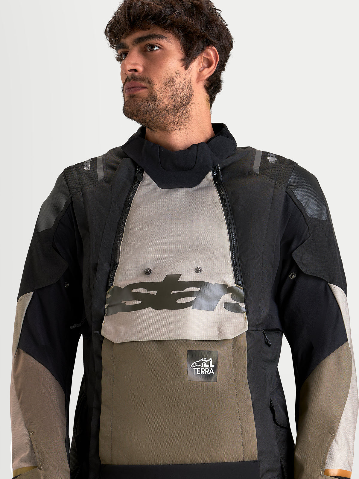 Alpinestars Harok V2 Drystar, chaqueta de moto de aventura para hombre, aluminio, marrón y negro, con diseño modular impermeable y detalle de bolsillo canguro frontal, vista en modelo