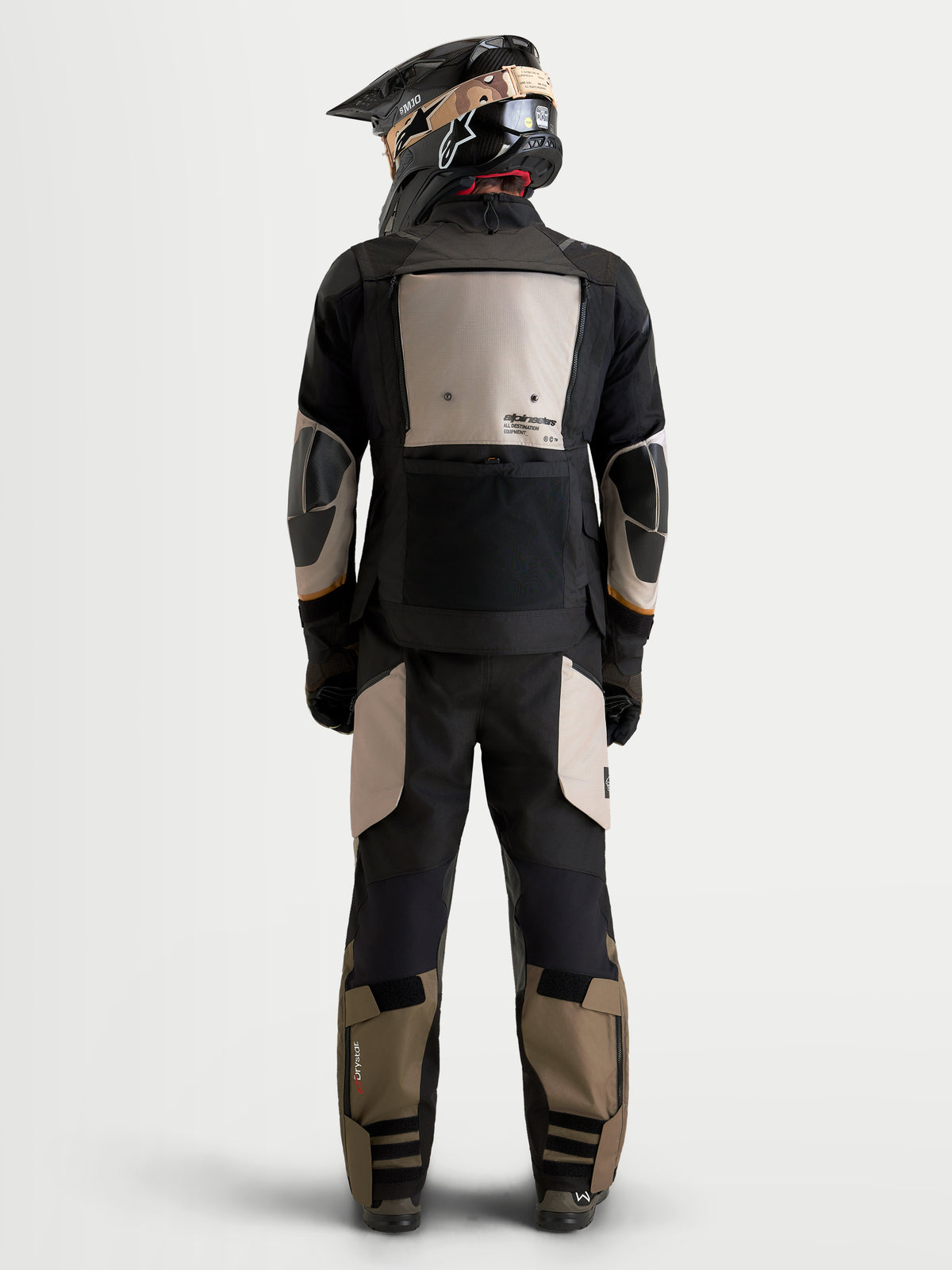 Alpinestars Harok V2 Drystar, chaqueta de moto de aventura para hombre, aluminio, marrón y negro, vista trasera de un piloto con equipo todoterreno y casco