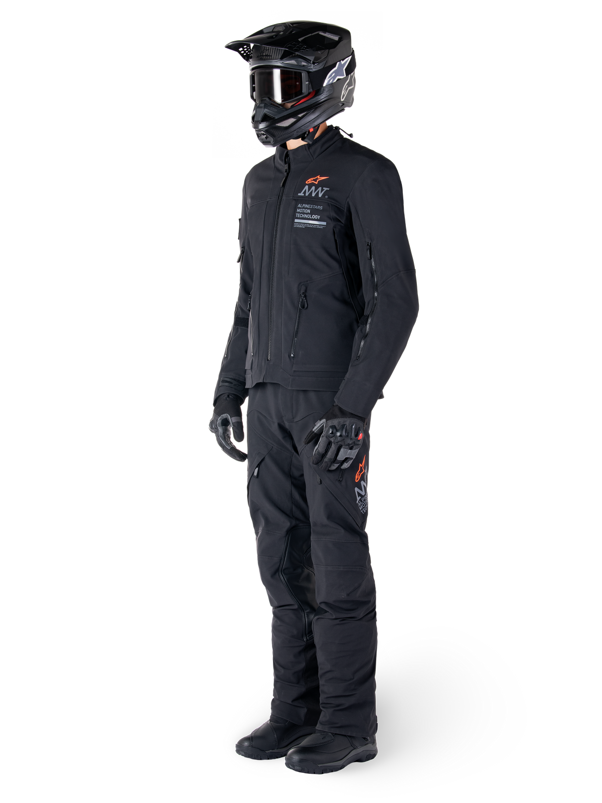 Chaqueta Alpinestars AMT-8 Stretch Drystar® XF, chaqueta de moto de aventura, negra, usada con pantalones a juego, casco y guantes, con la marca Alpinestars Motion Technology y detalles en naranja, construcción elástica duradera para conducción de aventura