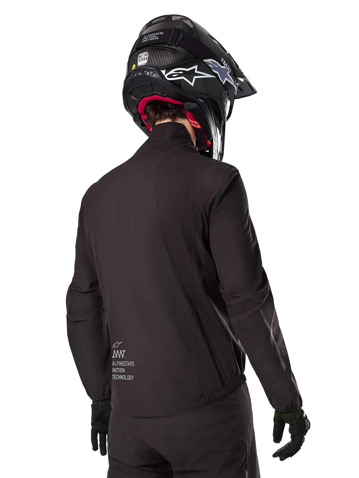 Alpinestars AMT-8 Stretch Drystar® XF Liner, forro de chaqueta impermeable negro, vista trasera de un piloto con casco y guantes negros, con el logotipo Alpinestars Motion Technology en la parte inferior de la espalda, diseño minimalista y funcional para conducción de aventura.