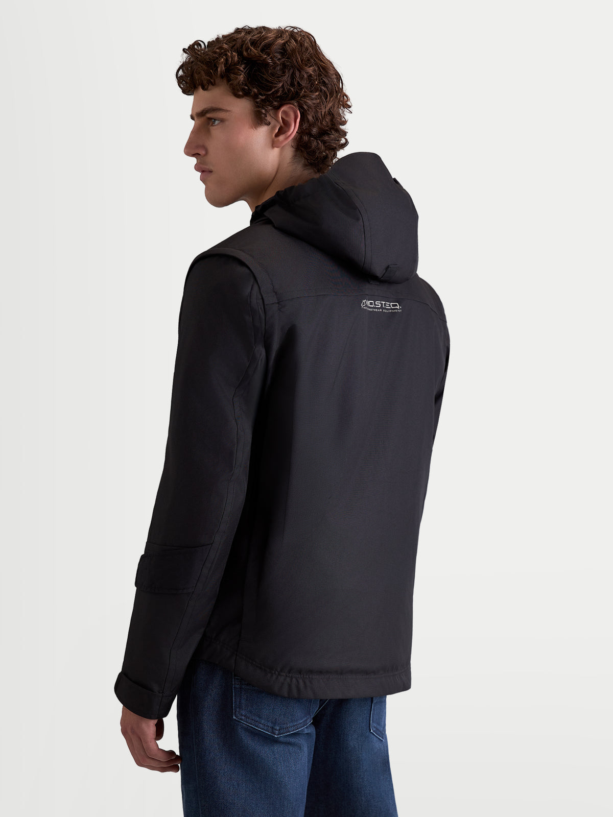Alpinestars Morfex Parka Waterproof Jacket, chaqueta de moto urbana contemporánea para hombre, negra, vista trasera en un modelo que lleva la chaqueta textil con capucha integrada