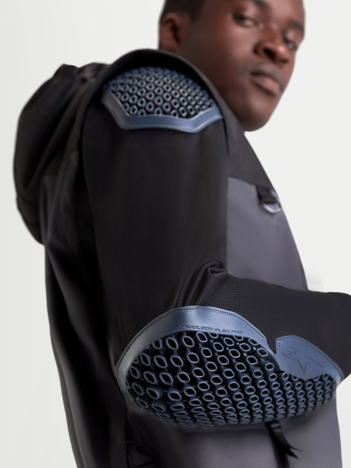 Alpinestars Morfex Parka Waterproof Jacket, men's urban motorcycle jacket in lunar gray and black, close-up view highlighting the integrated Nucleon Flex Pro Level 2 shoulder and elbow armor worn by a model.