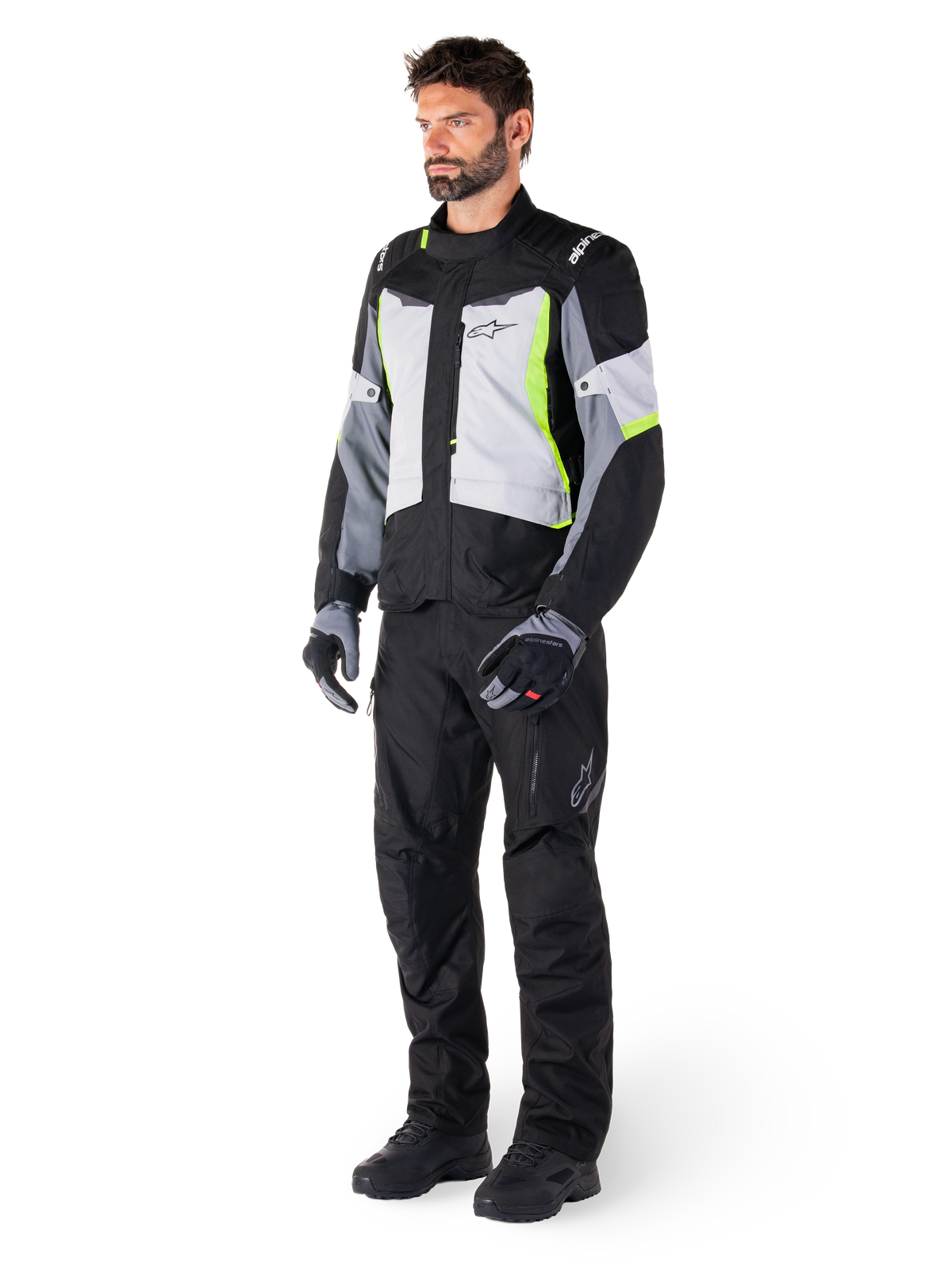 Alpinestars ST-1 Waterproof Jacket, Adventure Touring Motorcycle Jacket, Ice Gray Black and Yellow Fluo, worn by a model with matching black pants and gloves, featuring a streamlined design with bright yellow accents and Alpinestars branding.
