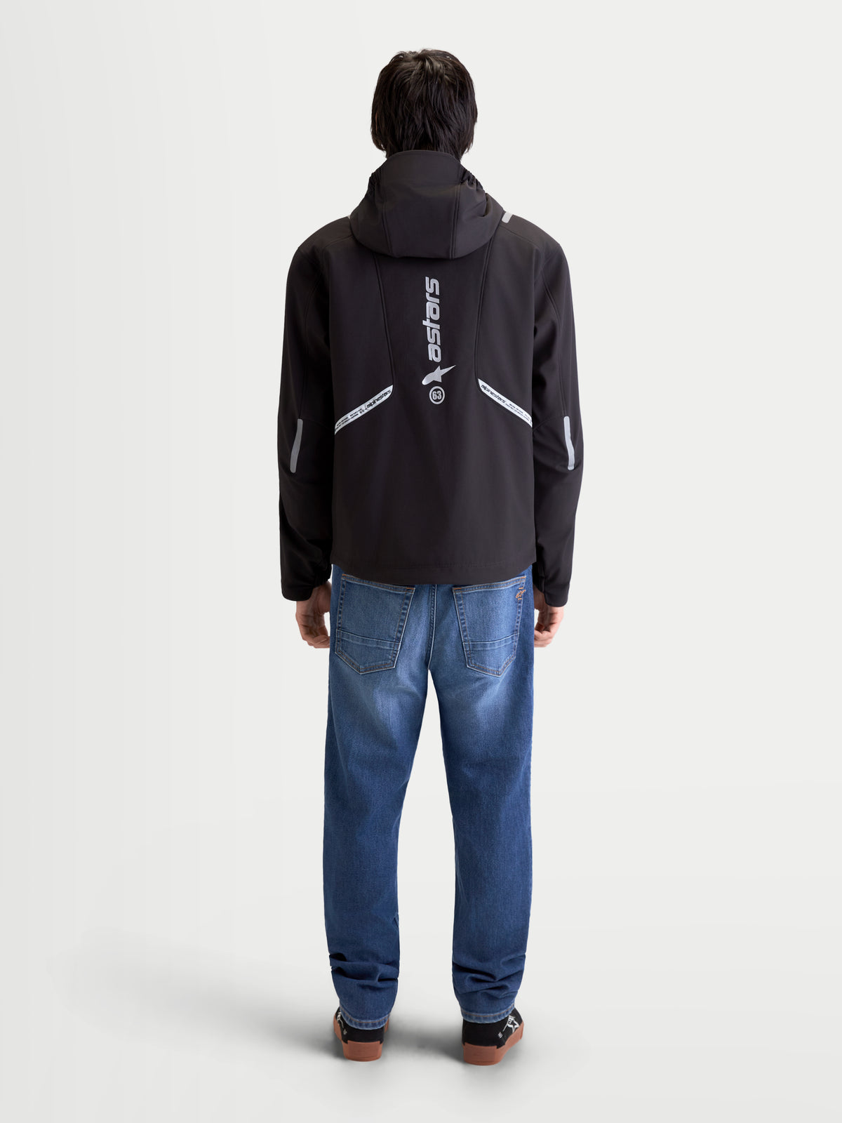 Alpinestars C 5 Drystar chaqueta, chaqueta de moto urbana contemporánea para hombre, negra, vista trasera de un modelo que lleva la chaqueta con capucha integrada y detalles reflectantes