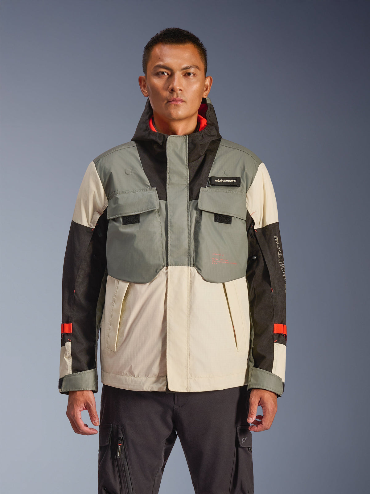 Alpinestars Mospher Waterproof Jacket, chaqueta de moto para hombre, diseño de bloques de color en gris, negro y crema, estilo de inspiración táctica con bolsillos en el pecho, sistema de capucha con cuello alto, detalles rojos en las mangas, equipamiento urbano para motociclistas