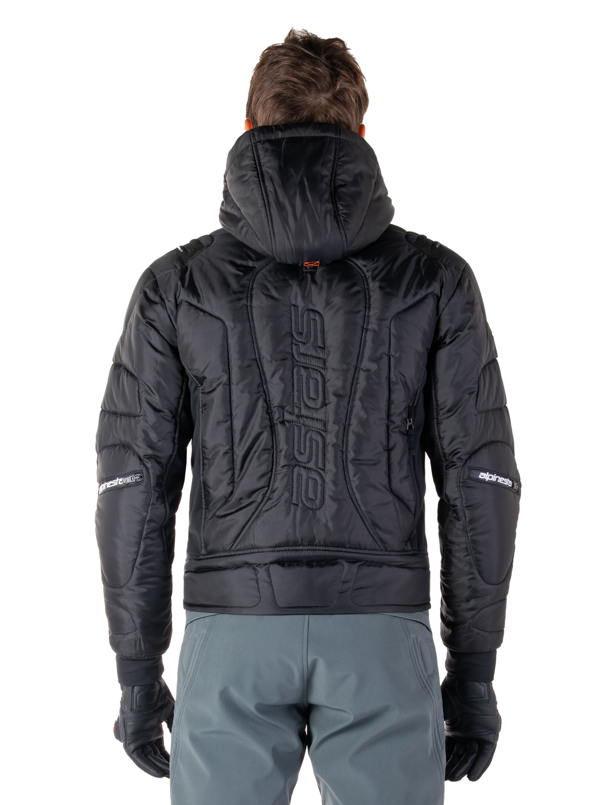 Chaqueta impermeable Alpinestars Mohobbs, negro, vista trasera que muestra la construcción acolchada, logotipo 'astars' vertical en la espalda, con capucha, estilo moto streetwear contemporáneo