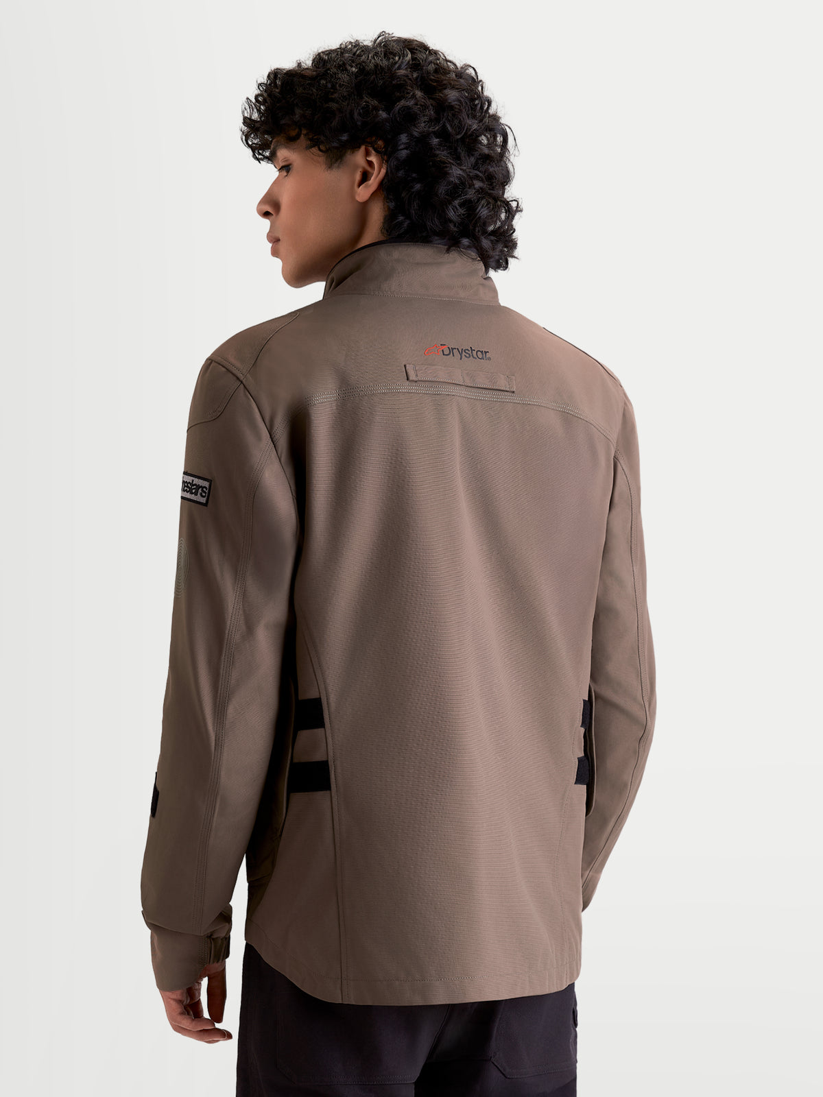 Alpinestars Altan Drystar Jacket, men's urban contemporary waterproof motorcycle jacket in walnut and black, rear view on a model showing the field-jacket silhouette and Drystar branding.