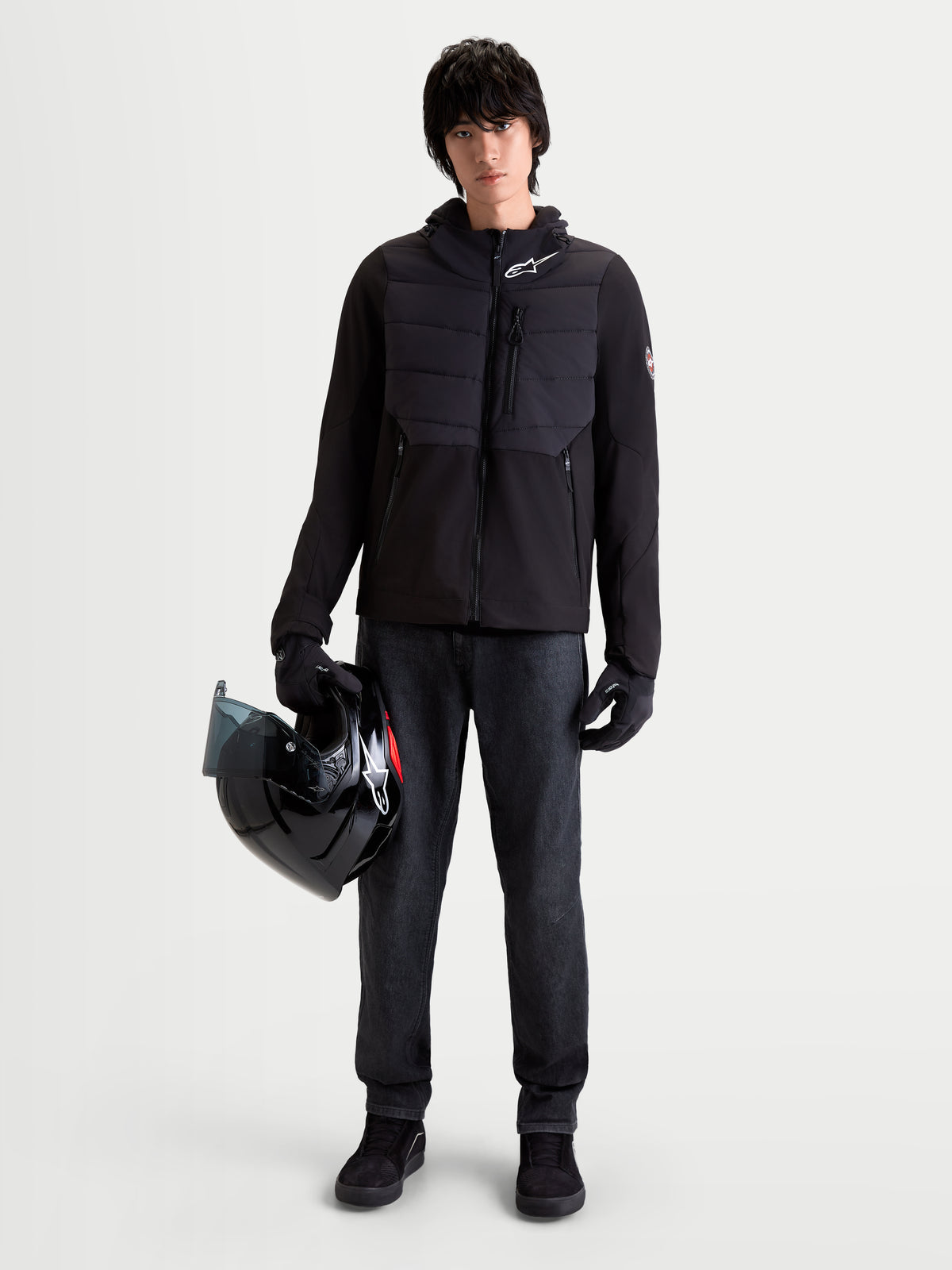 Alpinestars Therma-Tech Waterproof Jacket, men's urban motorcycle riding jacket in black, front view on a model wearing matching gloves and holding a helmet, featuring sonic-welded down construction and softshell textile