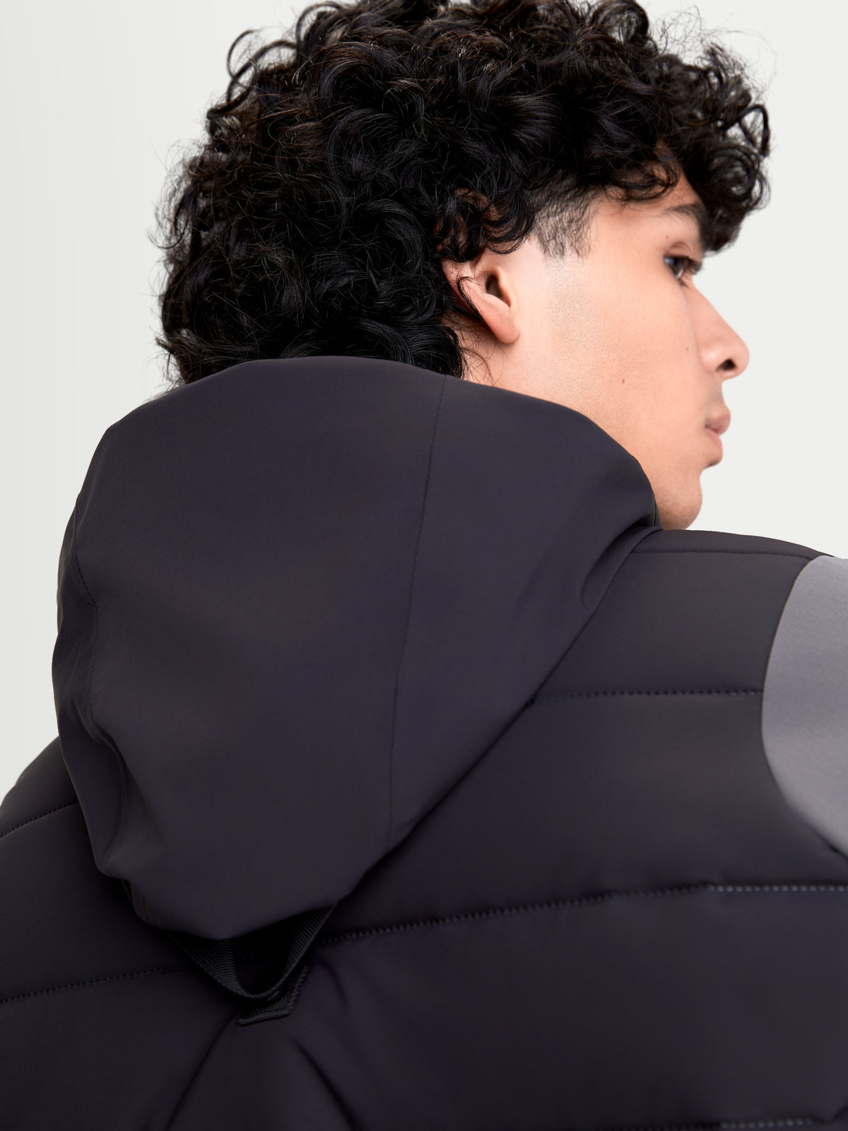 Alpinestars Therma-Tech WP Jacket, chaqueta de moto urbana de hombre en negro y gris oscuro, vista trasera en primer plano de la capucha integrada y construcción acolchada en modelo