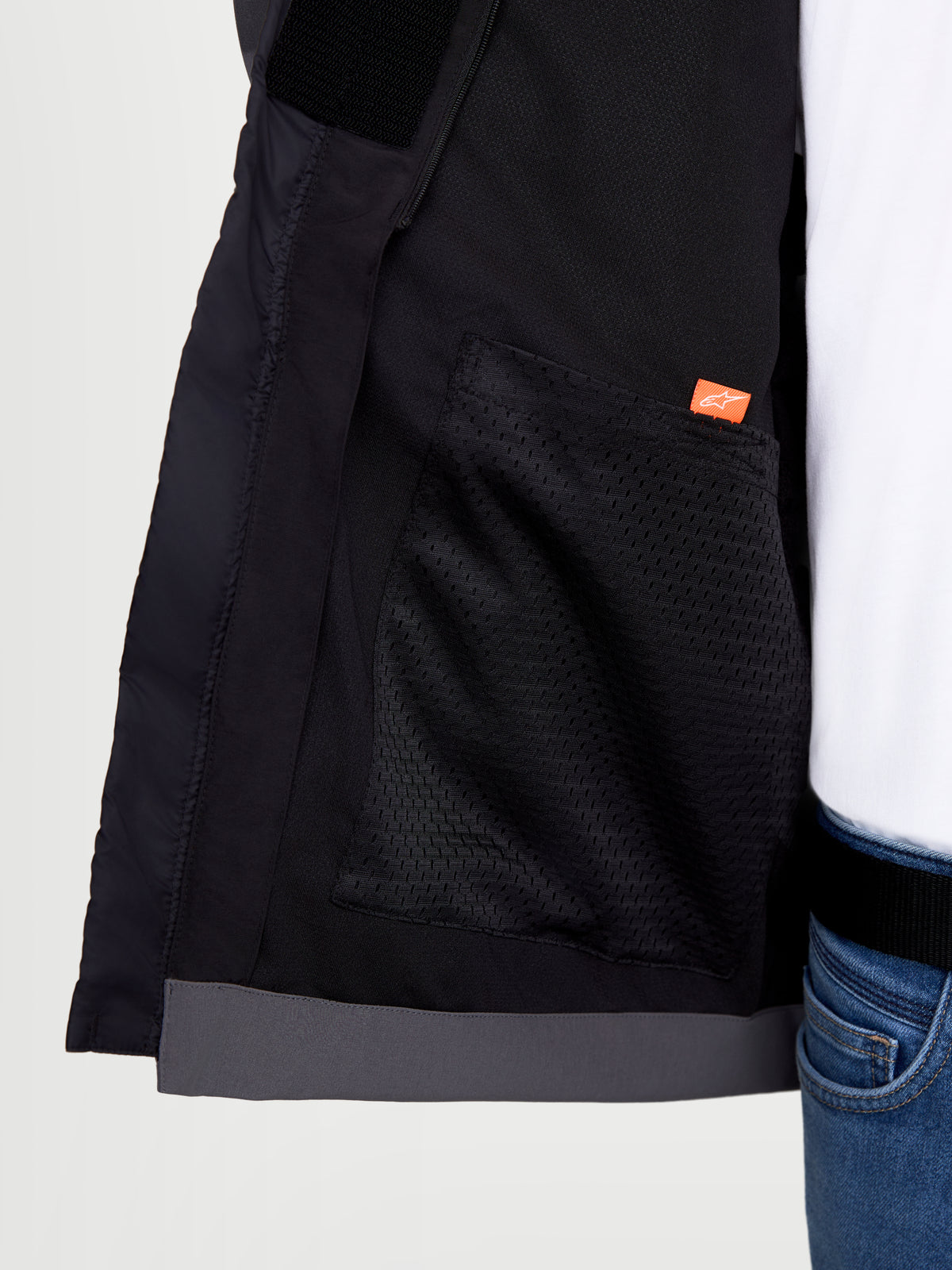 Alpinestars Therma-Tech Waterproof Jacket, chaqueta de moto urbana, vista interior en primer plano que muestra el bolsillo de malla y el detalle del logotipo de la marca, negro y gris oscuro, construcción de tejido softshell