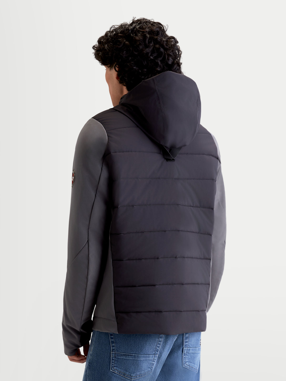 Alpinestars Therma-Tech Waterproof Jacket, chaqueta de moto urbana para hombre en color negro y gris oscuro, vista trasera en modelo mostrando capucha integrada y construcción acolchada